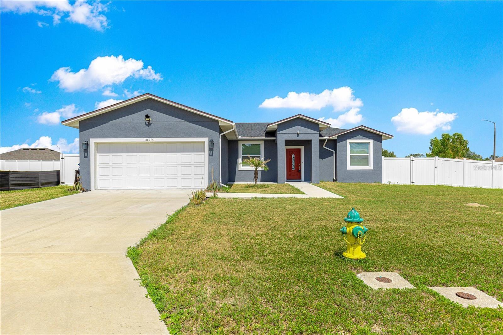 Welcome to this stunning 2022-built home featuring an open floor plan with 10-foot ceilings with recessed lighting throughout and a vaulted ceiling in the living room, creating a spacious and airy feel. Located on a desirable corner lot, this property is fully enclosed with a vinyl privacy fence and offers a blank slate for landscaping, ready for your personal touch. Imagine putting in a beautiful pool and fire pit in the back yard giving you your own private oasis!Step inside to elegant porcelain rectangular gray tile flooring with minimal grout lines throughout the entire home. The gourmet kitchen boasts quartz countertops and center island with breakfast bar, dark gray cabinetry, bi-fold barn door on the pantry, wine refrigerator, marble backsplash and stainless steel appliances-perfect for both everyday living and entertaining. The master suite offers a luxurious retreat with a slipper bathtub, walk-in shower, and dual sink vanity. 2 guest bedrooms and a full guest bathroom with shower/tub combo available for your family or guests. Custom touches like multiple barn doors offer a stylish, modern flair. Other features include inside laundry, all furniture included-truly move-in ready and a 2-car garage with finished floor and utility sink. Don't miss this opportunity to rent a beautifully designed, turnkey home with premium finishes in every room! This home is close to The Villages and Ocala. Lake Weir is just minutes away as well.