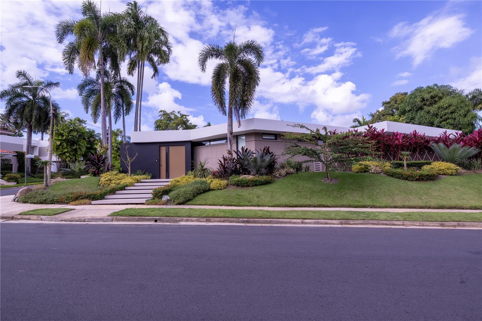 Luxury Home for Sale in Garden Hills North, Guaynabo, Puerto Rico. Discover elegance and modern design in this fully remodeled three-bedrooms, four bathrooms, powder room, office, and flex room. The open-concept layout seamlessly integrates living, dining, family, bar area and kitchen spaces, with expansive windows that fill the home with natural light and providing stunning views of the lush gardens. Designed by Interior Designer Carlos AlegrÃa, every detail reflects a nature-inspired theme, from the custom Copatlife Italian kitchen and bar with Sub-Zero and Wolf appliances to the designer lighting, furnishings and details throughout. All custom-made designer furniture and accessories were carefully selected to follow the colors and theme of every room.
The master suite features a spa-like en-suite bathroom, rainfall shower, double vanities, and a walk-in closet designed by California Closets. Additional highlights and spaces include an office room, flex room with three 84 inches wide, 8K TVs, a state-of-the-art technology system, laundry room, and wired internet access points throughout the home. Outside, the meticulously landscaped backyard designed by Mery Bingen provides a heated pool, Jacuzzi, and expansive terrace, perfect for relaxation or entertainment. The pool features bullnose lights and multi-color options, enhancing the vibrant outdoor atmosphere.
This property, with a living area of approximately 4,000 square feet and a corner lot size of 1,372 square meters, also includes a power generator and a water cistern for added convenience and security. Located in a peaceful yet convenient neighborhood, the home features additional luxury items like electric curtains, blackouts, impact windows and doors. The property's spectacular landscaping is a work of art, having a variety of native plants and flowers that provide year-round beauty and privacy. Attention to details in the garden design ensures a tranquil and picturesque environment.
The Garden Hills neighborhood offers easy access to schools, shopping centers, restaurants, and major highways, while still providing a peaceful, secluded retreat.
This residence provides more than just a home; it provides a luxurious lifestyle. Don't miss the opportunity to make this dream home your reality! Contact us today to schedule a private showing!