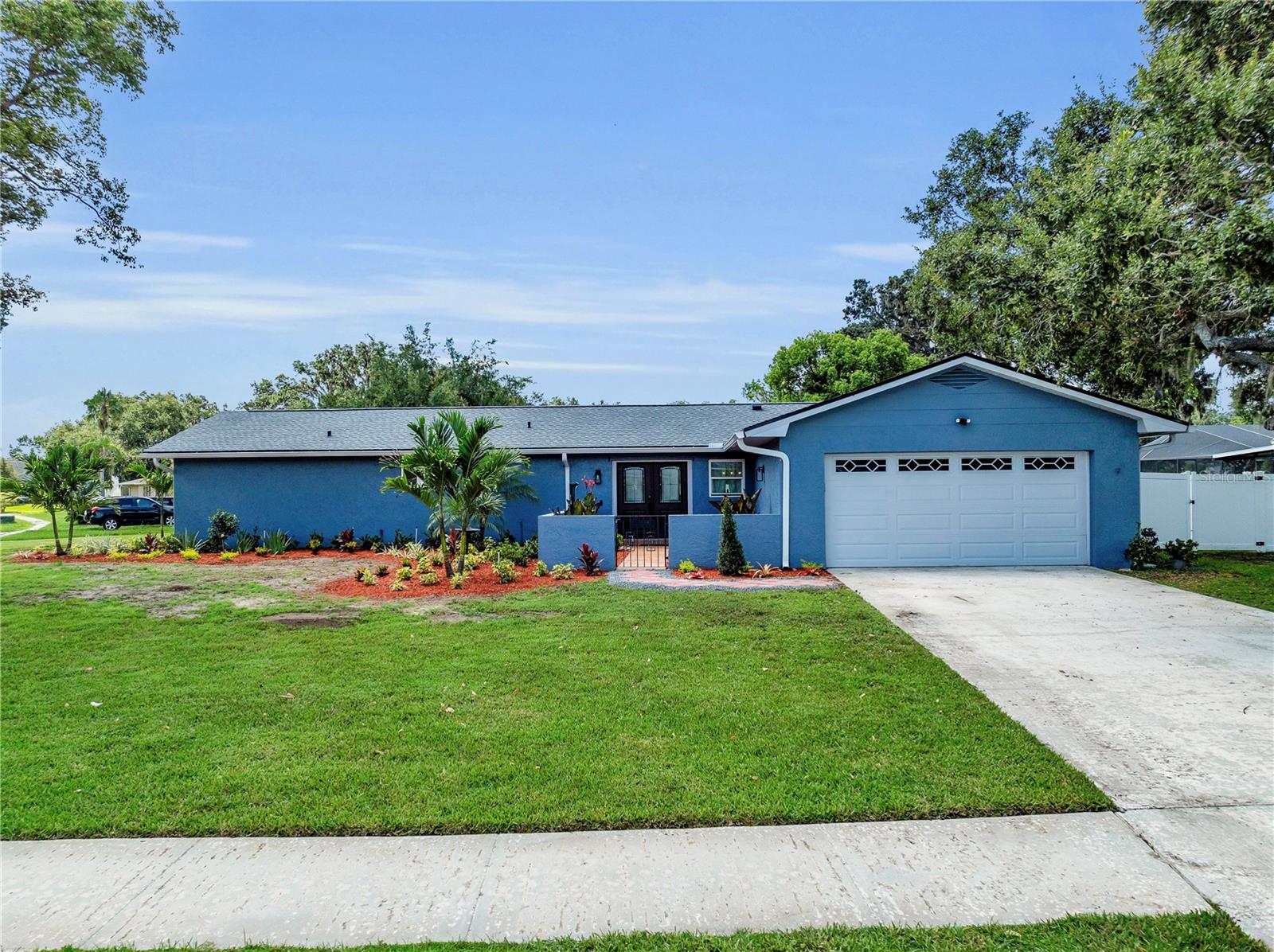 Welcome to this one-of-a-kind, move-in ready home situated on a massive corner lot just shy of half an acre, with no HOA and no CDD. From the moment you arrive, you'll notice the brand-new professional landscaping that enhances the curb appeal and frames the beautifully updated exterior. Nearly every major system in the home has been updated, including a newer roof (2022), new plumbing (2017), newer A/C (2018), water softener (2017), and hot water heater (2018). The windows and sliding doors were replaced in 2023, flooding the home with natural light and providing easy access to the expansive outdoor space.
Inside, the home features a stunning custom kitchen with quartz countertops, soft-close cabinetry, an induction cooktop, and double ovens. The living room is truly unique, with high ceilings, exposed wood beams, and a charming wood-burning fireplace. Both the primary and guest bathrooms have been beautifully updated with brand-new vanities and mirrors. Throughout the home, there is no carpet, and sliders in every room open up to the outdoors, making indoor-outdoor living a breeze. The custom wet bar adds a perfect touch for entertaining.
The fully fenced yard is an entertainer’s dream, offering an enormous outdoor space with plenty of room for gatherings, gardening, or even a future pool. A detached shed provides additional storage. This home blends modern updates with charm and character and is truly a rare opportunity. VA Assumable Loan Ask For Details!! Don’t miss your chance—schedule your private showing today before it's gone!
