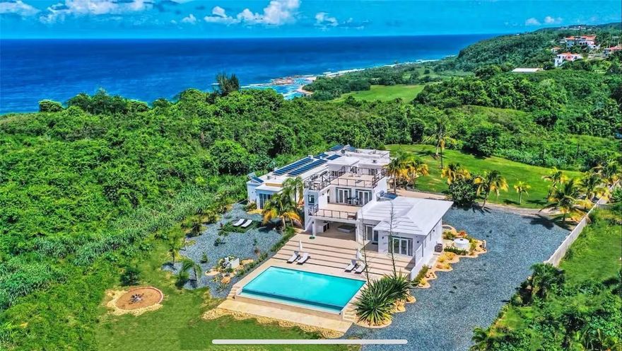 Coastal Living Surrounded by Nature and Design

Tucked within the serene coastal landscape of Bo. Coto in Isabela, this remarkable villa sits alongside the golf course at the Royal Isabela Hotel, offering a rare blend of seclusion, scale, and scenery. With views that stretch across green fairways and extend toward the Atlantic Ocean, this property invites a lifestyle defined by tranquility, natural beauty, and understated elegance.

The estate is currently arranged as a 7-bedroom, 6-bath residence, thoughtfully divided between two structures. The original home was rebuilt in the early 2000s, while the more recent wing was completed in 2019, creating a harmonious layout that can comfortably serve as a private retreat, a multi-generational residence, or a high-performing investment.

A spacious rooftop terrace offers the perfect setting for morning meditation, yoga sessions, or taking in the sun as it rises and sets over the ocean horizon. The outdoor area also includes a 40 x 20 foot infinity pool that appears to flow into the green edge of the golf course, surrounded by palms, coastal breezes, and open skies.

The villa’s flexible design and rental history make it a compelling opportunity for short-term rental operators seeking a high-performing coastal asset with room to scale. For those seeking a private residence, the home offers comfort, privacy, and effortless access to nature.

Located just moments from Playa Pastillo—one of Isabela’s most picturesque and uncrowded beaches—you’re also within easy reach of renowned surf breaks, scenic cliffs, and the local charm that defines Puerto Rico’s northwest coast.