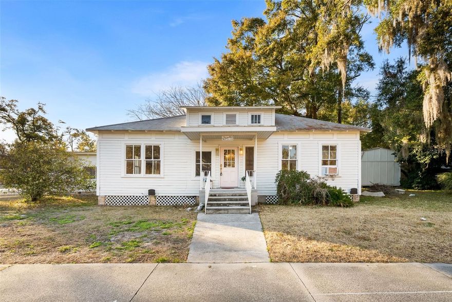 Charming, fully updated historic property situated on a picturesque, tree-lined street just moments from downtown High Springs — with valuable mixed-use zoning allowing both residential and commercial use. Whether you’re seeking a character-filled home, a live/work setup, or a prime spot for your business, this property offers outstanding flexibility.
Welcomed by a classic front porch with coach-style lighting and surrounded by native perennial landscaping, this three-bedroom, two-bath residence blends timeless charm with modern upgrades. Inside, original wood floors add warmth and character, while the kitchen, dining area, and bathrooms have been tastefully renovated for today’s lifestyle. High ceilings, spacious rooms, a functional floor plan, and custom built-ins highlight the craftsmanship of this 1940s-era gem.
Positioned on a desirable corner lot, the property features an oversized one-car carport, additional parking for two vehicles, a large storage shed, hobby/workbench space, and a covered patio retreat nestled among mature greenery — perfect for relaxing or entertaining.
Located within a vibrant mixed-use district of historic homes and thriving local businesses, you can stroll to High Springs’ popular restaurants, antique shops, boutiques, and community activities. The area’s beautiful crystal-clear springs are just a short drive away.
Rare opportunity to own a property zoned for both commercial and residential use in a prime High Springs location. Schedule your private showing today!