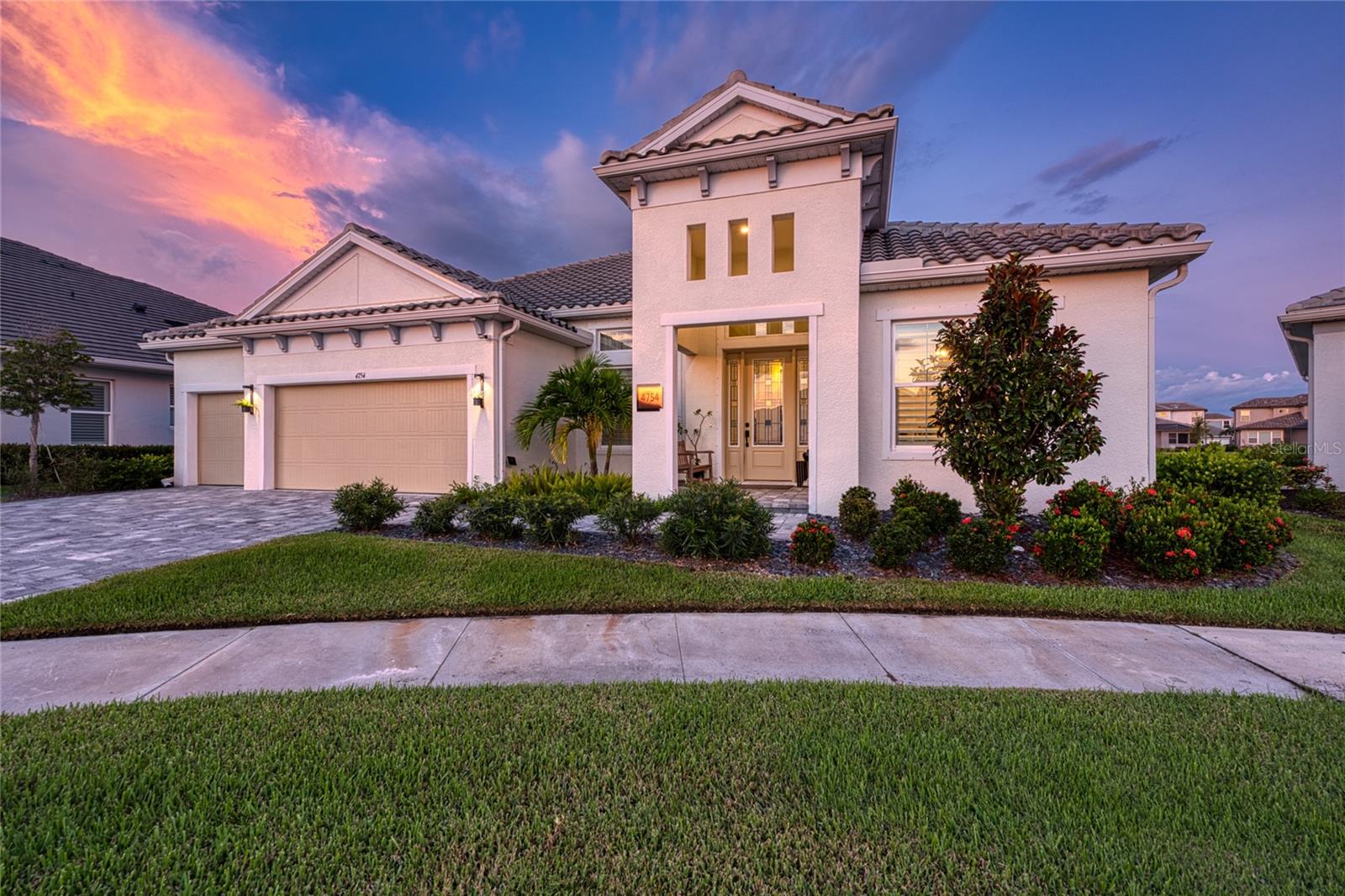 Discover luxury with this exceptional waterfront residence, meticulously designed with an emphasis on harmony and luxury. This sprawling 4 bedroom, 3 bathroom, lap-pool home encompasses 3,308 square feet of living space on a premium lot giving you a 180-degree panoramic water views and situated in a serene cul-de-sac. Property was built with the highest level of upgrades available through the builder. The striking curb appeal invites you in, showcasing a paver driveway, a covered entryway, a tile roof, and meticulously manicured landscaping. Upon entering, you will be captivated by the luxury upgrades, timeless architectural details, volume ceilings, abundant natural light, and Italian wood-look tile that flows throughout the home. The floor plan and design are truly showcased with a refined sense of elegance and functionality with every detail thoughtfully planned with timeless luxury and comfort in mind. Impressive dining room features a coffered ceiling, modern lighting, and custom wall accents, setting the stage for memorable gatherings. Enjoy the expansive living room seamlessly connects to the kitchen, offering views of the water and pool area. The Chef’s kitchen is a true highlight, complete with quartz and Cambria countertops, ceiling-height cabinetry, stainless steel appliances including a built-in oven, gas cooktop, and pantry plus butler’s station for optimal organization. Enjoy casual meals in the dinette or at the breakfast bar, adorned with contemporary lighting. The versatile bonus rm can serve as a family rm or any additional space you envision. French doors lead to an office/den, providing an ideal setting for work or study. Retreat to the spacious primary bedrm, which boasts direct access to the lanai and large picture windows that invite natural light. The spa-like ensuite bathrm features a freestanding garden tub, dual vanities, upgraded glass-enclosed shower with two shower heads, and two custom walk-in closets. Three additional generously-sized bedrooms offer ample space. Quality plantation shutters are custom made, pure linen curtains will capture your attention. The laundry room is equipped with quartz countertops, cabinetry, and a deep sink, plus there is a custom mudroom-style organizer in the garage. Step outside to your outdoor oasis, which optimally integrates indoor and outdoor living. The covered patio is perfect for lounging and includes rough-ins for an outdoor kitchen. Dive into the inviting saltwater lap pool or unwind in the spa. The upgraded, fully screened enclosure offers an open-unobstructed views of the water. The pool is positioned to obtain a full day of natural light reducing your need for heating. Additional features include smart home technology, security system, seamless gutters, home water softener system, generator rough-in ready, upgraded insulation for energy efficiency, and epoxy flooring in the garage. Located in the gated community of Worthington with low HOA fees and no CDD, residents can enjoy a scenic shell walking trail that winds through the neighborhood. This home is conveniently situated near downtown Sarasota, I-75, Tampa, St. Petersburg, the UTC shopping district, and the breathtaking beaches of Siesta Key, Lido Key, Longboat Key, and Anna Maria Island. This is a rare opportunity to own a lakefront sanctuary that beautifully blends luxury, design, and Feng Shui harmony. Designed with elemental balance, symbolic energy flow and Feng Shui, truly a one of a kind home.