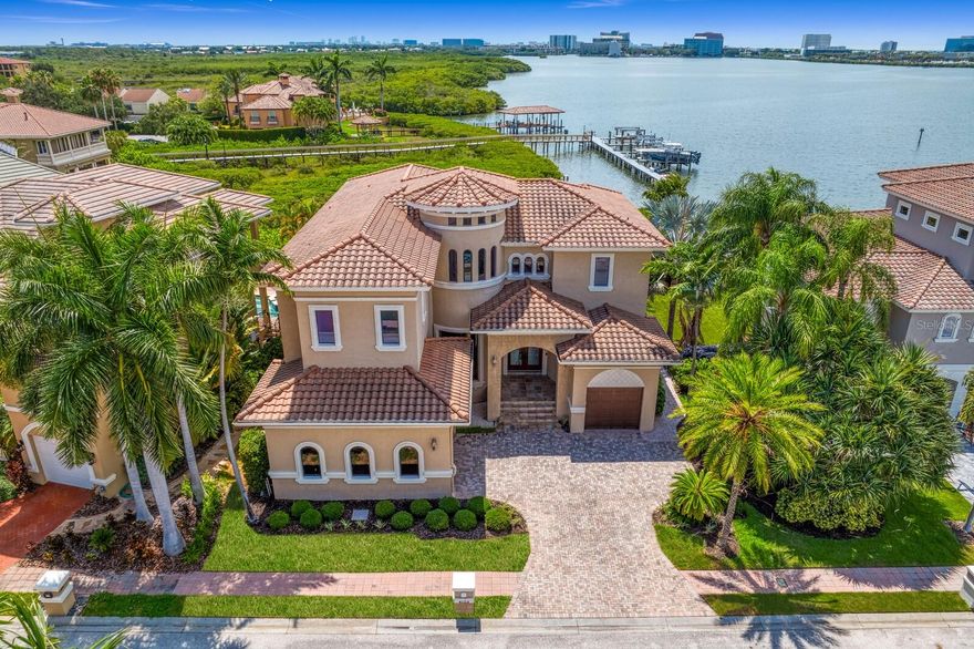 Superior Waterfront Lifestyle in The Reserve of Old Tampa Bay. Dramatic architectural design features, soaring ceilings and sweeping water views create a refined waterfront oasis in this private gated community on Tampa Bay. You’re welcomed by an impressive foyer to spectacular architectural details, soaring ceilings, concave floor-to-ceiling windows, arched doorways and a flowing floor plan perfect for entertaining in this custom Alvarez-built 5 bedroom, 4.5 bath home. Featuring a formal living room and formal dining room, a guest bedroom with French door access to the pool area, along with 1.5 baths on the first living level. The bright center island kitchen offers stunning quartz countertops and top-of-the-line stainless appliances, butler’s pantry and casual bar seating overlooking the inviting family room with fireplace and additional casual dining area perfect for breakfast or game night. Expansive windows capture the pool area and water views beyond, with French door access to the heated pool and spa, covered lanai and outdoor kitchen. Have the best of the boating lifestyle with a dock and your own boat slip at the common dock. A dramatic stairway leads to the second level and an open loft landing with sitting area. A dedicated space for a restful retreat is found in the exceptional primary suite with wall-to-wall water views, private terrace, luxurious bath with deep soaking tub and glass shower, along with an expansive closet/dressing area. The second level also features 3 well-appointed ensuite bedrooms, with one guest room offering a private waterfront terrace. Enjoy thoughtful attention to detail throughout, with statement lighting, wood grain tile floors, paver drive and 3-car garage. Offering easy access to open water, enjoy an envied waterfront lifestyle with boating, fishing and water sports right from your backyard. Experience distinctive waterfront living and coveted privacy minutes from downtown Tampa, shopping, sports venues, Tampa International Airport and Berkeley Prep School (5 minutes).