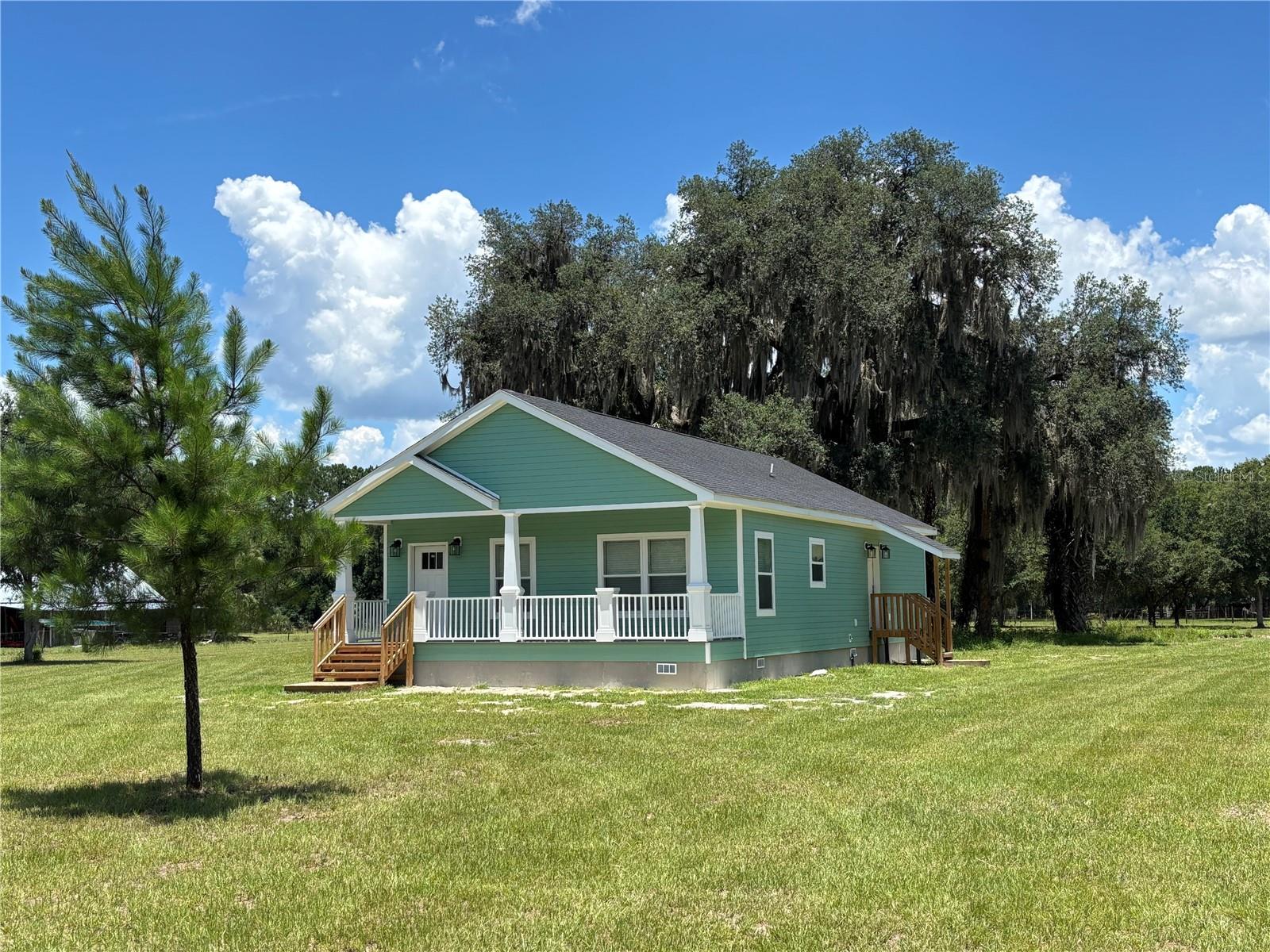 Modern New Construction on 5 Acres in Historic Cross Creek
Welcome to your peaceful retreat in the heart of Old Florida. Nestled beneath a canopy of majestic oak trees and set well back from the road for ultimate privacy, this brand-new 2023-built home offers the perfect blend of modern comfort and timeless Southern charm—all just minutes from the Marjorie Kinnan Rawlings Historic State Park and boat ramp in the desirable Cross Creek community.
Situated on a fully fenced, picturesque 5 acre parcel, this thoughtfully designed 3-bedroom, 2-bath home offers a total 1,476 square feet of open-concept living space with soaring ceilings, elegant crown molding, and abundant natural light throughout. The spacious living area flows seamlessly into the gorgeous kitchen, featuring granite countertops, stainless steel appliances, soft close cabinetry, and plenty of storage—ideal for everyday living and entertaining alike.
The primary suite is a serene escape with high ceilings, a large walk-in closet, and a beautifully appointed en-suite bath complete with a double-sink vanity and a walk-in shower. Two additional bedrooms also offer high ceilings and ample space for guests, family, or a home office. An inside laundry room with outdoor access adds extra functionality to the layout.
Built with durable Hardie Board siding and a concrete stem wall foundation, this home was constructed with both style and longevity in mind. Relax on the covered front porch with a pair of rocking chairs and take in the serene views of your oak-dotted landscape—there’s plenty of space here to create your dream mini farm, garden, or simply enjoy the natural beauty with abundance of wildlife in Cross Creek.
With convenient access to both Gainesville and Ocala, this is your opportunity to own a slice of quiet country living without sacrificing accessibility. Come experience the best of Florida's natural charm and make this one-of-a-kind property your forever home.