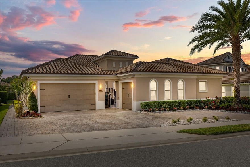 A rare offering in Lake Mary's coveted Steeplechase community. Behind a barrel-tile roof, warm stucco facade, and arched window detailing, this Mediterranean-inspired residence distinguishes itself from the moment you arrive, mature date palms, manicured rose-and-hedge landscaping, and a paver driveway leading to a 3-car garage configuration.
Pass through the wrought iron gate into a private walled courtyard, a true Mediterranean villa moment with paver flooring, decorative iron accents, and string-lit ambiance. The arched entry opens to a foyer with soaring tray ceilings, sculptural chandelier, crown molding, and continuous wood-plank tile throughout.
A light-filled formal sitting room with coffered tray ceiling and crystal chandelier serves equally as a refined dining or music room. The home opens dramatically into an expansive great room with deep tray ceilings and triple sliders framing the resort-style pool beyond.
The chef's kitchen is the heart of the home: raised-panel cream cabinetry with glazed detailing, leathered granite counters, full-height shimmering mosaic backsplash, and a professional stainless suite, French-door refrigerator, gas cooktop with separate induction surface, double wall ovens, vented range hood, and farmhouse apron sink. Dual built-in wine refrigerators flank the cabinetry. An oversized island seats six beneath glass bell pendants, while a gold sputnik chandelier crowns the bay-window breakfast nook overlooking the pool.
The owner's retreat is a sanctuary, an oversized suite with dual tray ceilings, matching brass sputnik chandeliers, a dedicated sitting room, and private lanai access. The spa-inspired primary bath delivers five-star luxury: dual espresso vanities with granite tops, an oversized garden tub wrapped in dark mosaic tile, frameless walk-in shower with dual rainfall heads, and a custom California Closets-style walk-in with floor-to-ceiling cabinetry. Three spacious secondary bedrooms and three full baths are all appointed with the same elevated finish package, granite vanities, espresso shaker cabinetry, oil-rubbed bronze fixtures, stone-look tile showers, so no space feels secondary. A dedicated home office sits behind glass-paneled French doors. A Jack-and-Jill bath connects two secondary bedrooms. The fourth bedroom functions as a true junior suite with its own en-suite. A pool bath with direct lanai access keeps wet feet out of the main living areas. The third-car garage has been converted into a climate-controlled home gym with mini-split A/C, epoxy flooring, and arched windows, easily restored to a garage at any time. Outside, an oversized panoramic screen enclosure with cathedral peaks shelters a custom freeform PebbleTec pool with dual sheer-descent waterfalls, color-changing LED lighting, raised spa with stacked stone spillover, and dual fire-and-water bowls flanking a Buddha centerpiece. The covered lanai features a fully equipped outdoor kitchen, built-in gas grill, professional vent hood, granite counters, beverage refrigerator, undermount sink, alongside alfresco dining and lounge seating. A separate pergola cabana with retractable shade canopy creates a third distinct outdoor "room" with fire pit conversation area. Mature privacy hedges ensure complete seclusion. Other upgrades include whole-home surround sound, smart mobile pool controls, fire bowls all app-managed.
A private resort behind a Mediterranean facade in one of Lake Mary's most desirable enclaves.