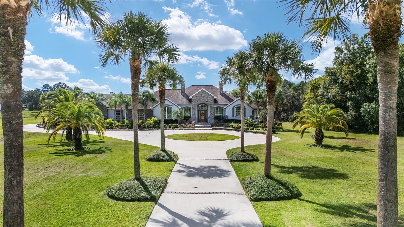 This amazing property features a custom home on 21 acres. Designed and built by the current owners with luxury in mind, this home is filled with all the comforts of home. This stately ranch house offers all the comforts and is bright and cheery at the same time. It also boasts an eat-in kitchen that overlooks the pool area and farm vistas. With three large bedrooms and three bathrooms, a great floor plan and an extra large walk-in closet in the master bedroom, this house is sure to please. The inviting pool area , 1 bathroom cabana and Sauna complete the set up.
This beautiful farm features a five-car garage, a security gate, and a palm tree-lined circular drive way. On a hillside, away from the house, there is a barn/garage that could easily be converted into a 10 stall barn. The proximity to HITS and WEC,– you can ride to HITS and it's just a 15-minute drive to WEC , make this the perfect place for the equestrian enthusiast. It would be our pleasure to show you around this wonderful farm. Priced to sell.