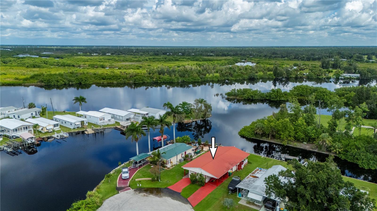 Waterfront Living on Shell Creek! This property offer 60 feet of creek waterfront with a concrete seawall. Fish right from your backyard and enjoy peaceful views of the canal, with birds gliding by and nature all around. Lovely manufactured home features 2 bedrooms and 2 bathrooms, plus a large living area, dining room, and a kitchen with ample cabinet and counter space. Solid vinyl and tile flooring throughout the bright and open well taken care of space. A separate laundry room includes a full washer and dryer. Step outside to a screened lanai, perfect for relaxing or entertaining, along with a back wooden porch, carport, and storage area. There's room to add a dock, giving you easy kayak or boat access to the Peace River and Charlotte Harbor. This property is in a quiet, private area with no HOA fees, and you own the land. With quick access to I-75 and Punta Gorda Airport just minutes away, it's ideal as a recreational retreat, seasonal getaway, or full-time residence. A rare chance to enjoy the waterfront lifestyle without restrictions or added fees.