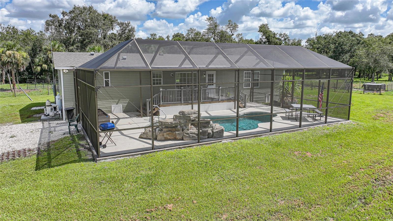 Discover the perfect balance of modern style and country charm with this beautifully updated 3-bedroom, 2-bath pool home on 20+ acres in a peaceful rural setting. Remodeled in 2023, the home boasts a stunning kitchen with new appliances, refreshed bathrooms with contemporary finishes, new flooring and baseboards, upgraded lighting and ceiling fans, new vinyl siding, and shingled roof. The screened in-ground pool area has been re-screened for a fresh, ready-to-enjoy outdoor retreat. The land is thoughtfully laid out for agricultural or equestrian use, fully cross-fenced into four separate pastures. Each pasture is supplied by a 4" well that feeds large blue water troughs, making livestock care simple and efficient. Two well-designed sets of pens with chutes make working animals convenient, whether for cattle, horses, or other livestock. The property also features two ponds and a creek, adding both natural beauty and functionality to the land. This is more than a home — it’s a property designed for those who appreciate the freedom and possibilities of country living without sacrificing modern comforts. Whether you envision a working ranch, a horse property, or simply a private retreat with room to roam, this one offers the space, features, and updates to make it a reality. Don’t wait—schedule your showing today. Seller financing considered.