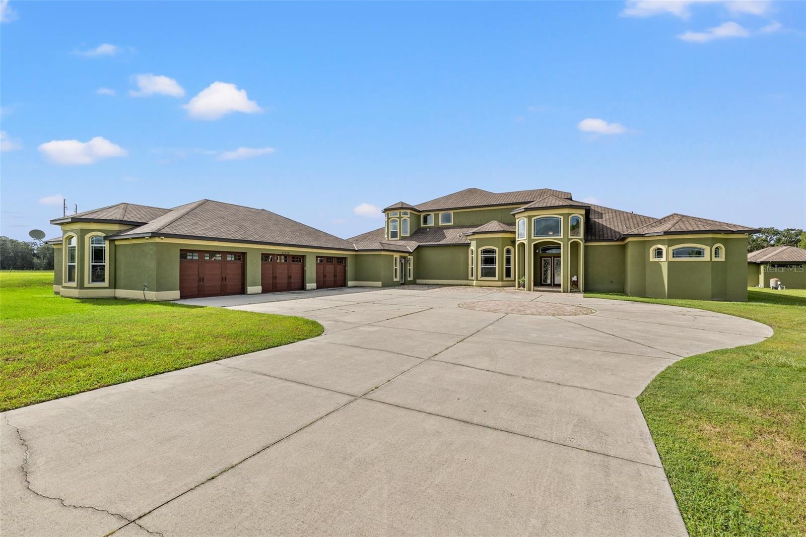 Welcome to luxury. This 9000 sq ft private estate offers 6 bedrooms, 5 ½ bathrooms, 6 car garage and an impressive array of amenities and features. This retreat-style property offers lots of privacy with a private, gated road and 5.1 acres of lush Florida landscape with substantial outdoor space for recreation, gardening and more. The beauty of nature follows you inside the home with stunning Travertine ceramic floors and light carpet that bring a sense of calm. The chef's kitchen boasts top-notch Thermador stainless steel appliances, including a 6-burner gas oven and double oven. Stone countertops, beautiful cabinets, and a walk-in pantry provide functionality and elegance. The open floor plan, gas fireplace, and center island in the kitchen create an inviting and conducive environment for entertaining guests and socializing. The gorgeous master suite is truly an oasis with lots of natural light in the spacious bedroom, 2 large walk-in closets, a double-entry shower, a spa tub, and dual vanities in the bathroom. Outside the master a sauna for some quick R&R. There are 4 bedrooms on the first floor, including the master suite, while the additional 2 bedrooms are upstairs. All bedrooms have access to their own full bathrooms, ensuring convenience and comfort for guests. The bonus area and loft are versatile spaces with a balcony overlooking the yard that could serve as playrooms, offices, additional guest rooms and more, allowing customizations that suits your needs. There is also a state-of-the-art movie room designed for an exceptional entertainment experience. High-quality audiovisual equipment and comfortable seating create a cinematic atmosphere within the comfort of your own home. You’ll easily maintain your fitness with the in-home workout facility complete with attached batting/golf cage for the sports enthusiasts. The home also boasts a 1,200 sqft, detached in-law suite perfect for hosting guests for extended stays. This separate living space with bedroom, bathroom, kitchen, and dining room, offers plenty of privacy and comfort for everyone. In addition to spacious living areas, this home also offers ample storage space, including a 6-car garage with plenty of room for vehicles and hobbies. This spectacular home caters to luxury living and is designed for entertainment, relaxation, fitness, and leisure and is not to be missed. It is conveniently located in the Tampa suburbs with excellent schools and access to shopping, restaurants, recreation, and Florida’s top beaches and attractions. Close proximity (across the street) to an equestrian center will allow the owners to enjoy horseback riding. Come home and enjoy the relaxed elegance of the Florida lifestyle at it's best!