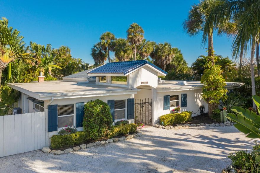 Nestled within the serene landscape lies this captivating sanctuary, offering  a 4-bedroom, 2.5-bathroom retreat sitting gracefully on one of the larger lots on Anna Maria Island, boasting a spacious 14,500 sq ft, presenting an exceptional opportunity for those seeking a permanent residence or a second home. Step into your private oasis, where a sprawling open pool awaits amidst lush tropical foliage and offers a view directly down the canal for an expansive view and providing a perfect setting for relaxation and rejuvenation. An additional feature is a deeded boat dock/slip adjacent to the property allowing you to embrace waterfront living without the waterfront price. Inside, discover a seamless fusion of modern comfort, with a thoughtfully designed split bedroom plan ensuring privacy and versatility for all occupants. The primary suite offers a peaceful retreat, while a charming Florida room offers an expanded living area. The heart of this home lies in its well-appointed kitchen, equipped with a 6-burner gas stove and double oven, creating a haven for culinary enthusiasts and entertainment alike. As night falls, gather around the wood-burning fireplace in the family room. Outside, a circular driveway welcomes you home and there is extra storage for all the toys too. Throughout the residence, Mexican tiles exude warmth and character, accentuating the coastal ambiance. This home offers an opportunity for you to refresh and make it your own. Seize the opportunity to own this slice of paradise in Holmes Beach, where waterfront living meets unmatched charm and potential.