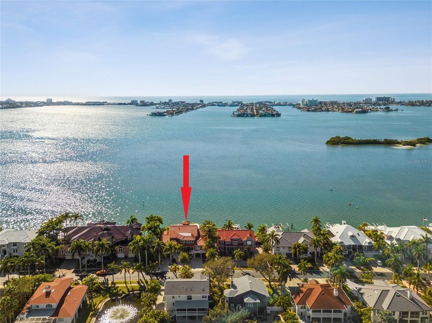 With stunning wide waterfront views of Boca Ciega Bay in nearly every room, and located in the premier neighborhood of Kipps Colony within the gated community of Pasadena Yacht and Country Club, this exquisite Mediterranean masterpiece is truly one of a kind.  A commanding exterior with superb curb appeal sets the stage as you enter with a Michelangelo travertine driveway and lush tropical landscaping which provides the ultimate privacy throughout the home and backyard.  A newer dock and two boat lifts, 40,000 lbs and 30,000 lbs allow for large boats and easy access to the Gulf of Mexico.  Enter the home to soaring ceilings in the living room with gleaming hardwood floors and LED lighting throughout. This home offers three bedrooms, four bathrooms and two half bathrooms and is 5,871 heated square feet. There is also an oversized elevator that reaches ALL three floors of the home. The elegant and spacious kitchen meets the needs of every culinary desire even the most discerning chef would want, a 6 burner Dacor gas cooktop, double ovens, 2 dishwashers, a large Sub-Zero refrigerator, two refrigerator drawers, ice maker, a Miele coffee maker, and an abundance of storage. The kitchen flows seamlessly to the family room with a gas fireplace, a built-in tropical saltwater fish tank, with access to the outdoor balcony that spans the entire home with a Heston outdoor grill and ample seating to enjoy the beautiful sunsets.  A theatre room equipped with a full wet bar with Ice make and dishwasher, movie projector, and half bath offer the perfect setting to entertain friends and family.  A second owner's suite with 2 walk-in closets, a jacuzzi tub, shower, a formal dining room, and an office complete the second floor. The third floor is exceptional with a beautiful owner's ensuite and with vaulted ceilings and a Miele coffee bar that includes a dishwasher and refrigerator. Luxurious ensuite bathroom is reminiscent of a spa and includes a private outdoor shower with sweeping water views. With views of the Don Cesar from your private balcony, this is truly a wonderful retreat!  The third-floor guest bedroom has an ensuite bathroom and walk-in closet.  The ground floor is the epitome of Florida paradise with a salt water pool and spa overlooking Boca Ciega Bay, a gas fire pit, and lounge area.  An outdoor kitchen and custom pizza oven create the ultimate entertainer's outdoor space.  Additional features include hurricane impact windows and doors, a custom home gym, climate-controlled wine cellar, whole house water purifier system, 6 outdoor security cameras, Control 4 audio visual system, 3 tankless hot water heater and so much more!  A coveted PYCC membership available without a waitlist to owners within the community with access to tennis, golf, renovated clubhouse and marina.