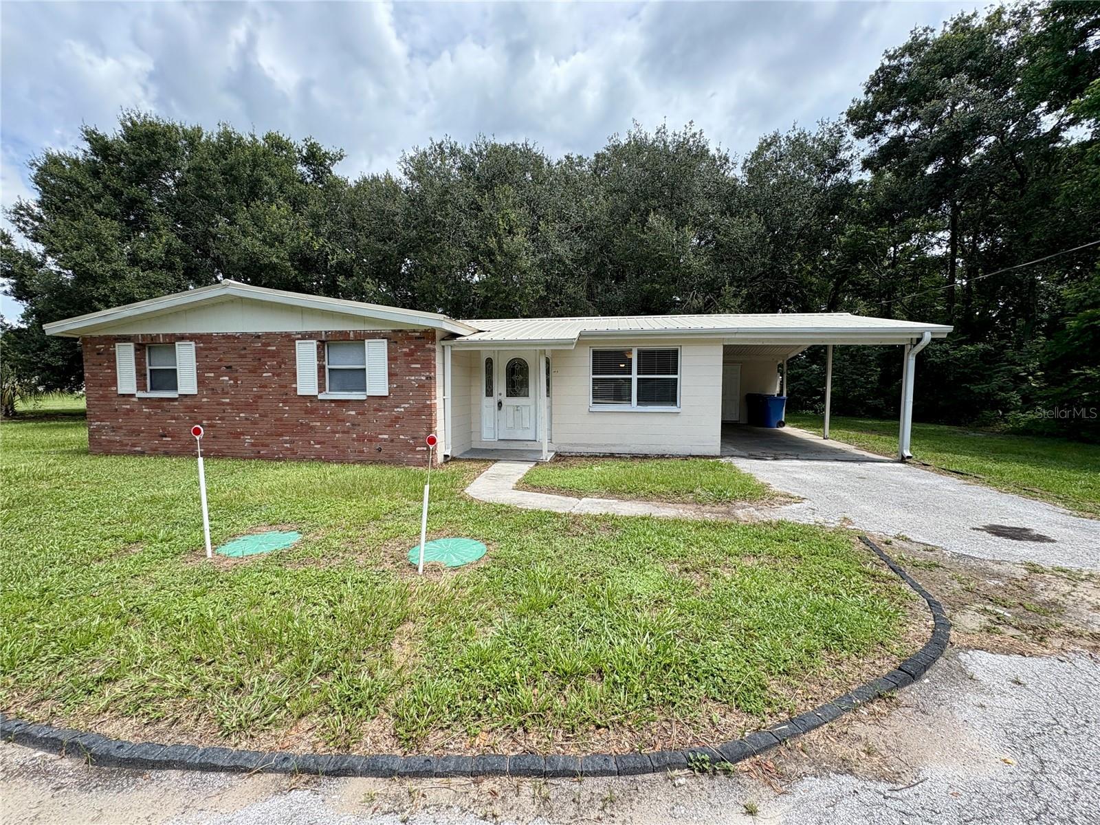 3-bedroom, 2-bath home tucked away on its own private lot, surrounded by mature trees—offering peace, privacy, and a serene natural setting. Featuring an open floor plan, tile flooring throughout this spacious layout seamlessly connects the living, dining, and kitchen areas—perfect for entertaining or relaxed everyday living. Large windows bring in plenty of sunshine, creating a bright and welcoming atmosphere. The covered carport offers protected parking with additional driveway space available.