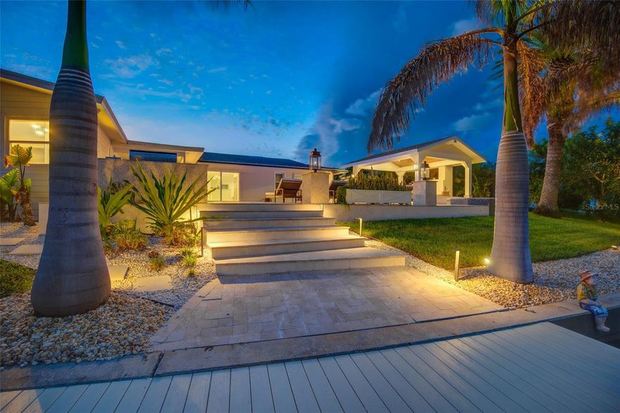 Waterfront living at it's best in desirable Island Estates! This gorgeous 3 bedroom, 3 bath waterfront home truly has it all! Boat lovers this is your dream home! 2 minutes to open water! Enjoy 100' of waterefront living. Slip 1 will accommodate up to 46' boat with 20' beam. Sailboats welcomed. There is also a covered slip with 10Klb lift! Deep water makes this a perfect waterfront playground! Dock is complete with both electric and water supply. Your sure to enjoy the composite decking too. This tropical oasis has a beautiful saltwater pool with travertine pavers and a beautiful heated waterfront spa. A must see is the 17x13 covered gazebo complete with built in gas fireplace, LED lights, ceiling fan, flat screen TV and cozy outdoor living furniture. Outdoor grill area complete with refrigerator & boaters will enjoy commerical ice machine. This home has seating on the lower dock area & is the perfect place for family & friends to gather. Saving the best for last is the indoor living space. Large open floor plan with must see water views. Polished terrazzo flooring, retractable patio slider off kitchen. Custom gourmet kitchen features white cabinets, oversized island with plenty of seating, dry bar with wine cooler, stainless steel appliances and stone countertops. You'll say wow when you see your spacious master bedroom with water view, double sink vanity, glass enclosed shower, oversized soaking tub and custom built master closet. The second waterfront master suite also has direct access to pool. This home has been fully updated to include impact doors and windows. Luxury furniture throughout this home.  2 car garage has plenty of storage for your water & beach toys.