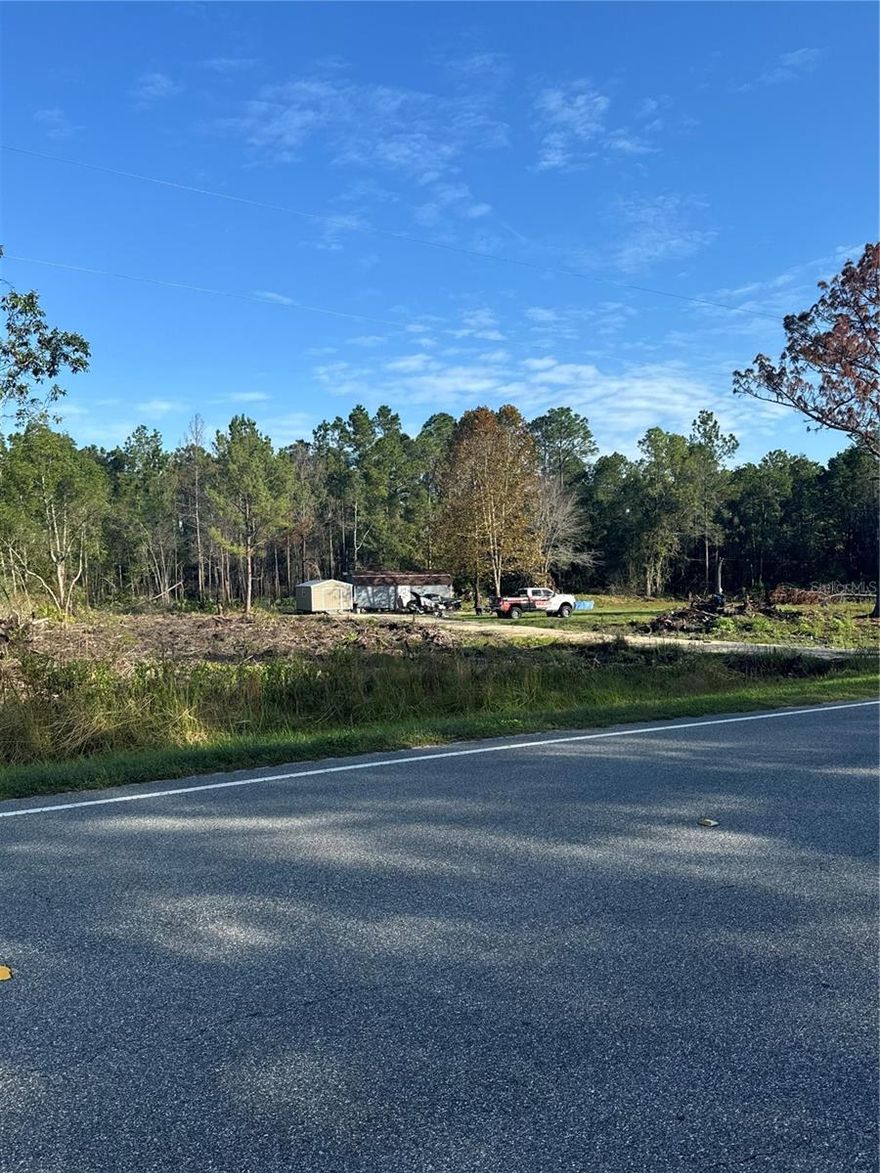 The property is located on Highway 318, 20 minutes from Ocala, 15 minutes from the Ocala National Forest, 40 minutes from the World Equestrian Center, 20 minutes from Salt Springs, and 15 minutes from Orange Lake. It has an electric power pole connected, a working water well, and a functioning septic tank. The property is 4.40 acres, with about 2 acres partially cleared, as seen in the photo. The property is zoned A1, allowing you to place a mobile home, build a house, or keep various animals.