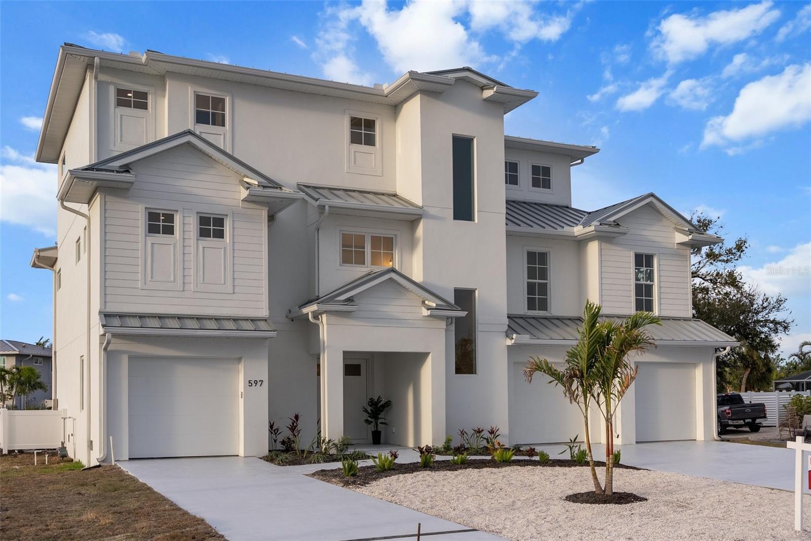 GULF AND BAY VIEWS! THREE OUTDOOR PATIOS! Discover an extraordinary coastal contemporary masterpiece by Floridian Crafted Homes, perfectly positioned on Longboat Key with breathtaking Gulf and Bay views. This 13 FEET ELEVATED, hurricane-fortified residence offers 5 bedrooms, 5 full bathrooms, and 2 partial bathrooms across 4,176 square feet of luxurious living space. Home has elevator shaft blocked in and ready to receive elevator mechanics. Designed for both elegance and functionality, this home features three expansive outdoor living spaces, including two private balconies and a stunning rooftop deck, perfect for capturing the serene Gulf sunsets. The open-concept great room flows effortlessly into the gourmet kitchen, creating an entertainer’s dream, while the second-floor club room offers a private retreat for relaxation. Outdoors, a private pool and spa provide a tranquil escape, while the 5+ car garage ensures ample storage for vehicles and beach essentials. Located just steps from the beach and steps to the upcoming retail and dining destination (Est. Fall 2025), this home also offers access to a community marina with available boat slips, making it ideal for boating enthusiasts. Experience the pinnacle of modern coastal luxury in this exceptional Longboat Key residence—where timeless design, breathtaking views, and an unparalleled location create the ultimate island retreat.
