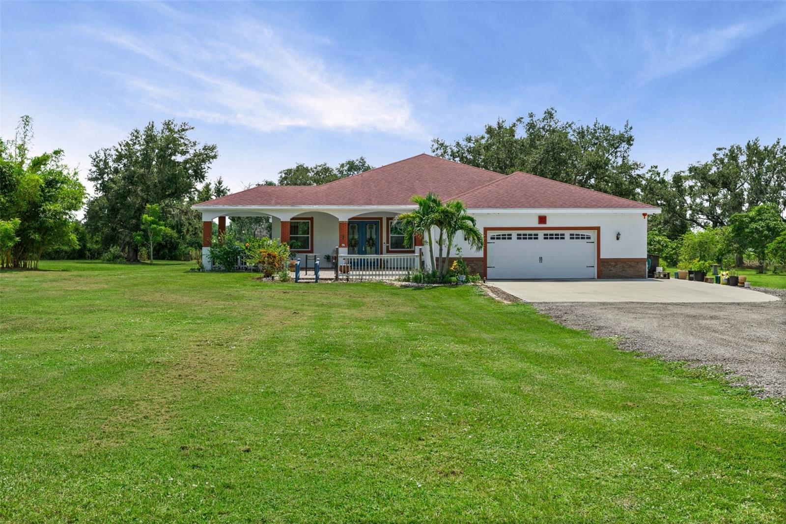 Welcome to this thoughtfully designed 2018 custom-built home, perfectly situated on 3.5 high and dry acres behind a gated private entrance. As you arrive, you’ll be greeted by a tree-lined driveway, shaded by majestic oaks and surrounded by an abundance of fruit trees, creating a serene and welcoming approach.
The home’s grand entry features elegant pavers and custom 8’ glass double doors, opening into an impressive open-concept living space with soaring 20’ ceilings. The home features impact-rated sliders and windows throughout, flooding the interior with natural light.
At the heart of the home, the gourmet chef’s kitchen is designed for both entertaining and everyday living. A sprawling granite island with copper double-basin sink provides ample seating, while high-end stainless steel appliances, a wine cooler, large walk-in pantry, and a pre-plumbed butler’s kitchen ensure every detail is covered.
This 4-bedroom, 3.5-bath residence offers multiple gathering spaces, as well as a versatile office/den off the foyer. Each bathroom features luxurious marble and tile finishes, creating a private, spa-like retreat.
The expansive backyard views are private and picturesque, with plenty of room to add a pool, guest house, or ADU—up to 80% of the main home’s size—making this property an excellent option for multi-generational living. With no HOA or deed restrictions, you have the freedom to truly make the property your own, whether you want to keep backyard chickens and livestock or store your boat or rv or build your dream workshop; all options are available here!
Located directly across from the Manatee River, outdoor adventures like fishing, kayaking, and boating are right at your doorstep. Despite the home’s peaceful, rural feel, you’re only minutes from exciting new amenities including the brand-new Lake Manatee K-8 school, a new Publix currently under construction, shopping & dining at Lakewood Ranch, Bayside Community Church, Hunsader Farms, Fiorelli Winery, Lake Manatee State Park, car racing tracks, and more. This home combines efficiency, elegance, and comfort in a location that offers both privacy and convenience.