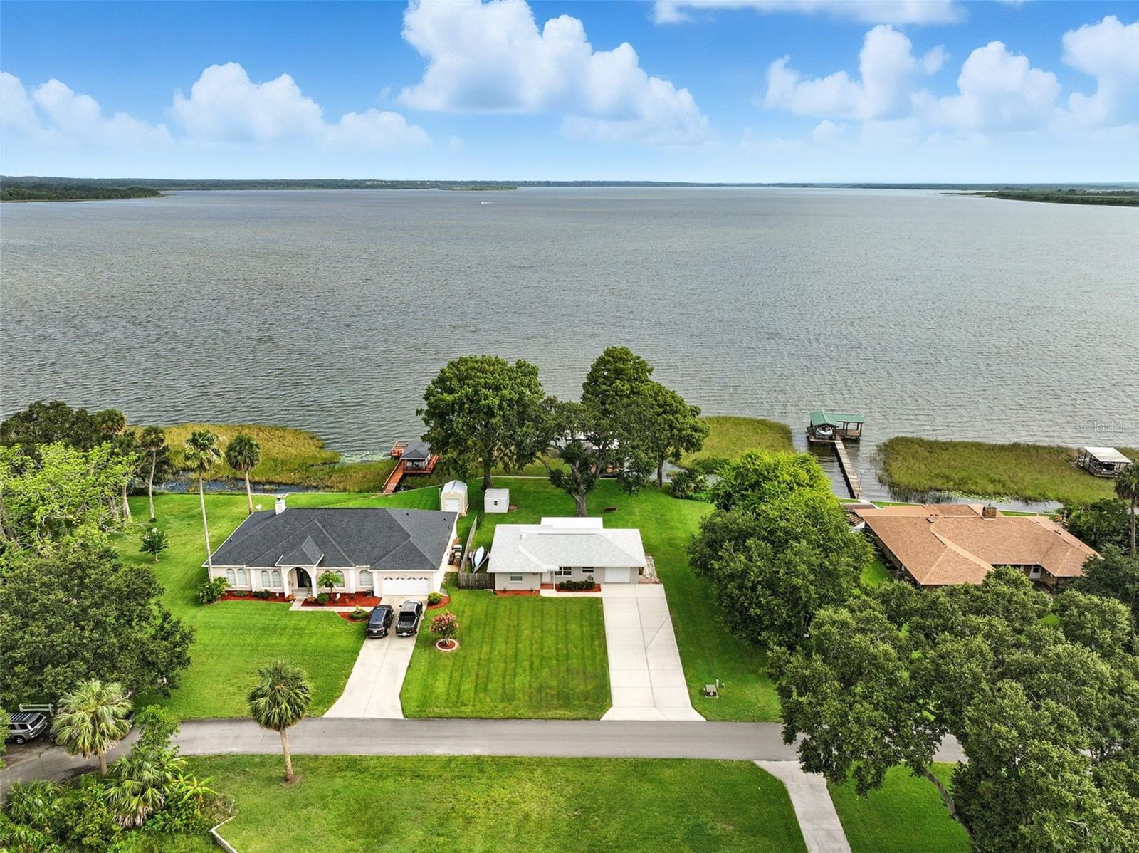 Welcome to this turn-key lakefront home in the desirable Treasure Island on Lake Griffin, part of the renowned Harris Chain of Lakes. Perfectly positioned on 75 feet of water frontage, the property includes a private dock with electric and water, ideal for boating, fishing, and soaking in peaceful sunset views. With no HOA, you’ll enjoy the freedom to fully embrace lake life on your terms.
This extremely well-maintained home offers peace of mind with thoughtfully completed upgrades throughout. The roof and gutters were replaced in 2022, the AC system was updated in 2018, and the hot water heater, pressure tank, and well pump were all replaced in 2023. Inside, you’ll find new flooring and baseboards (2025), fresh interior paint (2025), and updated plumbing, electrical, and windows from previous renovations. Appliances have also been refreshed with a washer (2021), dryer (2023), and a newer refrigerator.
A bright and airy Florida Room and screened patio provide year-round enjoyment of the lake views, while the oversized bedrooms offer generous space and storage. Outside, the dock and seawall have been professionally redone by the current owners and remain in excellent condition, offering a durable and inviting space for all your waterfront activities. The spacious backyard—with a tree swing and room to roam—adds charm and versatility. Whether you're canoeing from your dock, riding bikes through quiet streets, or simply enjoying the peaceful setting, this home is the perfect blend of comfort, updates, and waterfront living.
If you're looking for a move-in ready property with character, functionality, and direct access to one of Florida’s most treasured lake chains—this is the one.