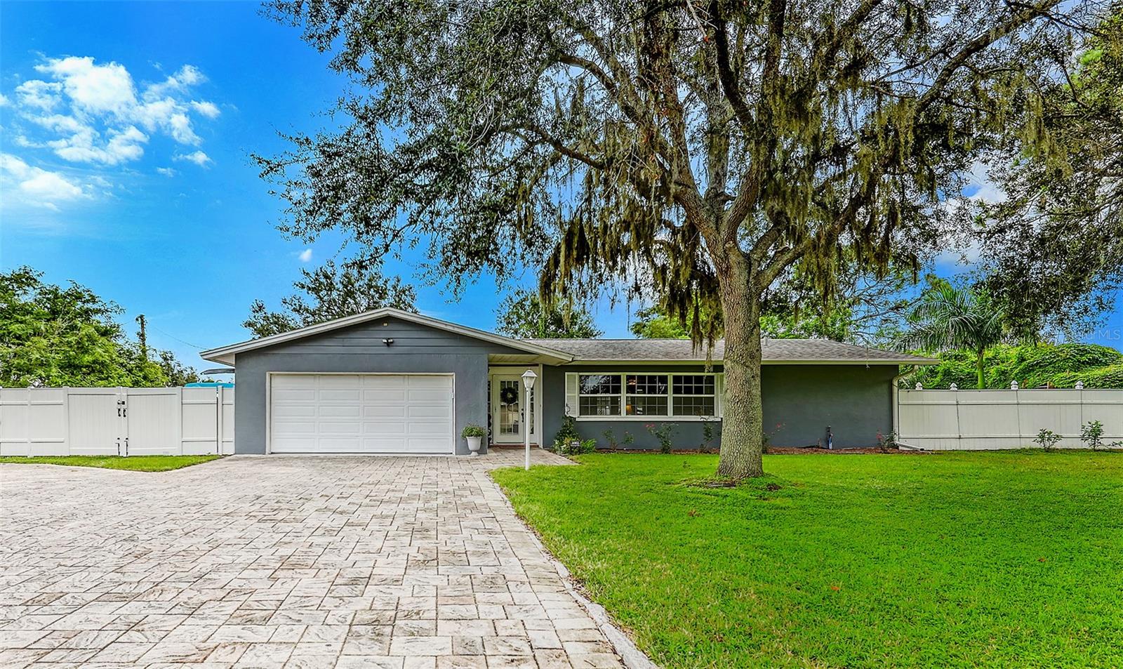 Welcome to your own slice of paradise! This warm and inviting 3 bedroom, 2 bath home is set on a sprawling oversized corner lot in the desirable Palm Aire Country Club community. Surrounded by majestic live oaks, royal and foxtail palms, flowering vines and fruit trees -including mango and moringa - this property is as lush as it is inviting. A paver circular driveway with RV/boat parking tucked behind a new vinyl fence make it both beautiful and functional. Inside the freshly painted interior offers a spacious split floor plan designed for both comfort and functionality offering generous living areas and room to grow. The updated kitchen features custom cabinetry, quartz countertops and stainless appliances plus a convenient pass through window to the pool area - perfect for entertaining. Step outdoors to your private retreat, where tropical landscaping frames a sparkling pool with a waterfall feature and jasmine draped arches. Enjoy sunrises over the pool relax and unwind in the above ground spa and picture the colorful sunsets from your front living room windows. Whether hosting friends or savoring quiet moments, this home delivers the best of Florida living. Beyond your front yard you're just down the road from Conservatory Park - a beautiful spot for walking trails and nature views - or enjoy the option to join the nearby golf course for leisure at your doorstep. In addition the home is conveniently located near UTC Mall, a wide variety of restaurants and shopping and just a short drive to some of Florida's best beaches. With no deed restrictions, HOA or CDD fees this tropical oasis offers freedom, privacy and a lifestyle to love.