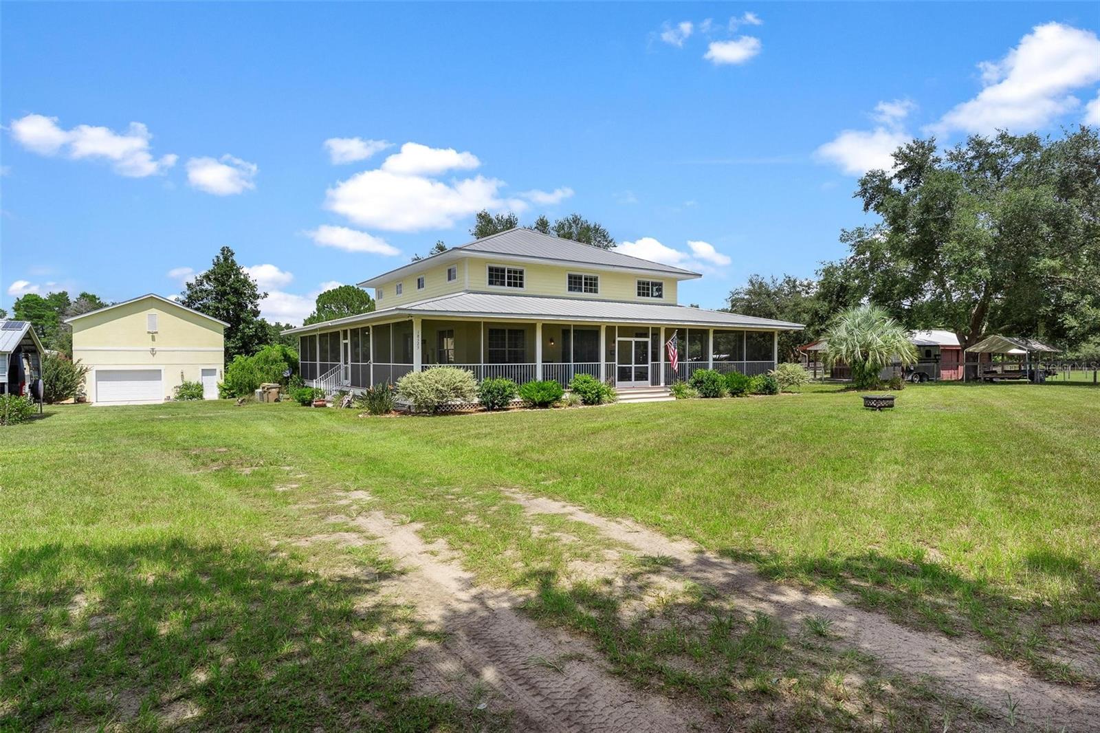 * BRING THE HORSES * TIMELESS QUALITY RETREAT with BARN, POOL, and GARAGE w WORKSHOP, fully FENCED AND almost 5 ACRES in RIDING DISTANCE to HORSE TRAILS. This beautifully designed home blends country living with modern comfort. Set on 4.6 FULLY FENCED ACRES, it features a WHOLE HOUSE GENERATOR, custom HORSE BARN, detached GARAGE-STUDIO with loft, and plenty of space for animals, hobbies, workshop and outdoor living. Highlights include a METAL ROOF, HARDIE PLANK SIDING, and a WRAPAROUND SCREENED PORCH overlooking your land. Inside, enjoy RICH WOOD FLOORS, a CHEF’S KITCHEN with GRANITE counters, gas range, walk-in pantry, and stainless appliances—all open to the living and dining areas. The primary suite offers a SPA-LIKE BATH and peaceful retreat. Enjoy the view of your horses grazing, or step outside to your private pool, the perfect spot to relax after a ride or entertain friends. With NO HOA and easy access to Ocala National Forest trails, this property is ideal for trail riders, equestrians, or anyone seeking space, privacy, and modern conveniences. CALL FOR YOU PRIVATE SHOWING, these DESIRABLE LOCATIONS are RARE!