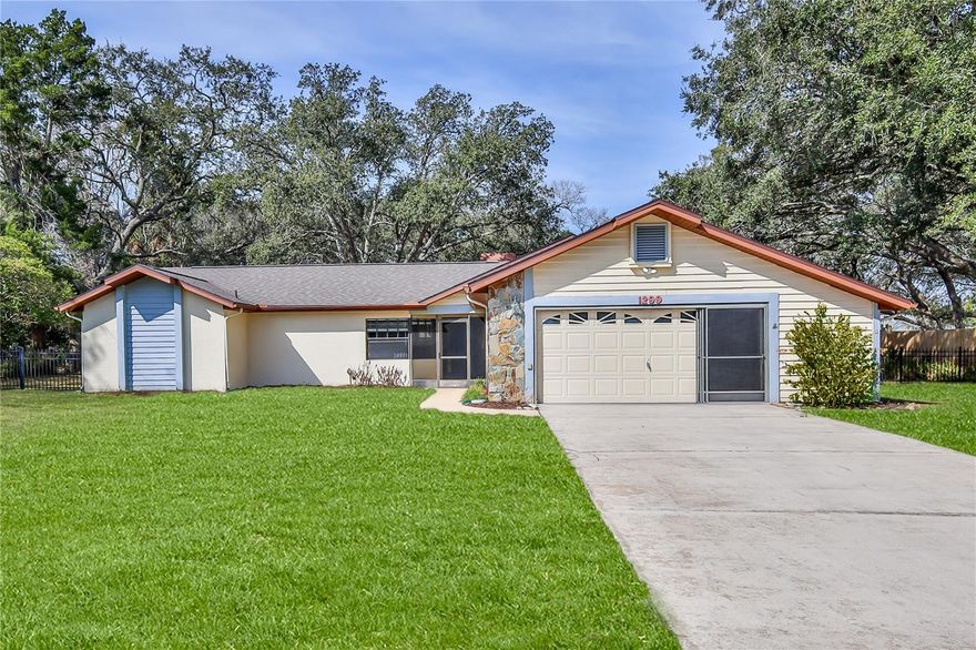 Set on just over half an acre beneath majestic grandfather oak trees, this 3-bedroom, 2-bath split floor plan home offers space, privacy, and character you simply don't find in today's newer builds. 
Inside, vaulted ceilings and updated luxury vinyl plank flooring create a bright, open feel in the living and dining room combination. The updated kitchen features soft-close wood cabinetry, solid surface countertops, glass tile backsplash, stainless sink, and a cozy eat-in area -- perfect for morning coffee while overlooking the beautifully landscaped yard. The family room is warm and inviting with its stone-faced wood-burning fireplace, vaulted ceilings and sliding doors that lead to the screened 10x19 lanai -- ideal for entertaining or relaxing under views of the oaks. A paver patio adds to the setting, a great place for your grill. The spacious primary suite includes a walk-in closet plus an additional wall closet. The en suite bath has been beautifully updated with dual sinks, wood cabinetry, and a large tiled shower. Two additional bedrooms share a full bath and hall linen closet, offering privacy thanks to the split floor plan design. Additional features include: Inside laundry with shelving and utility sink, Oversized 2-car garage with side entry door and workshop space, Fully fenced backyard with room for a garden, pool, or play area. HVAC 2016. Roof 2022. NO HOA.
If you've been looking for room to breathe, mature trees, and a home with warmth and personality -- this is it.