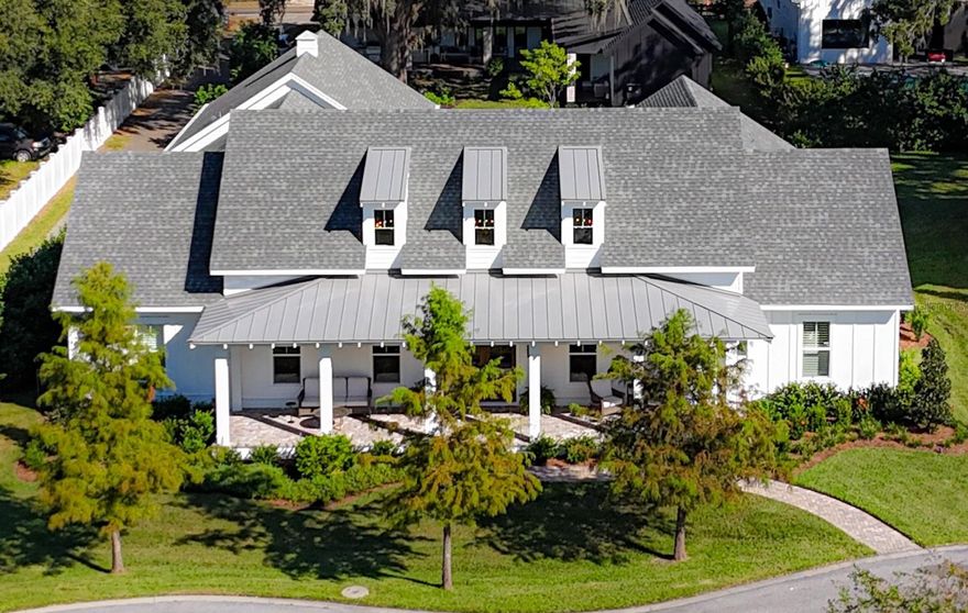 WELCOME to this beautiful CUSTOM HOME located in the highly desirable area of Winter Garden. Step into a blend of elegance and technology as you approach this FULLY FURNISHED, one-level home in a quiet cul-de-sac within the sought-after Oakland Hills community of Winter Garden.This spacious residence offers a perfect blend of comfort and style, featuring an open concept with natural light. The  exterior, a mix of Hardie board siding and brick, is framed by a large, shaded front porch featuring authentic gas lanterns from New Orleans. At night, landscape lighting accentuates the home’s lush greenery, highlighting the attention to detail.
Entering the grand great room, you’re greeted by soaring 22+ foot ceilings with exposed beams and dormers that flood the space with natural light. Throughout the rest of the home, 10-foot ceilings continue the airy ambiance. Custom moldings, baseboards, and LBU lighting with LED bulbs add elegance, while hardwood floors extend through the home (except in the media room). The main kitchen is a chef’s haven with Monogram appliances, two islands, and a 36" gas range paired with Moen and Kohler fixtures. The cabinetry, crafted by Wellborn, includes soft-close doors and drawers, adding to the quality and functionality. A back kitchen provides additional space with double ovens, a microwave, commercial Keurig, and ample pantry storage.
To the side, a cozy library/office creates a tranquil escape with custom-built bookcases. The primary suite is a luxurious retreat with its spacious layout, leading to an ensuite with an oversized Kohler clawfoot tub. For guests, two additional suites feature king beds and double-sink ensuites, while the bunk room includes its own private bathroom—ensuring everyone feels at home.
The media room delivers an elevated entertainment experience with a 4K projector and Atmos sound system. Step outside to an expansive outdoor living area, complete with a summer kitchen featuring a natural gas Coyote 36” grill, exhaust vent, steel doors, and automatic drop shade. 
Beyond the aesthetics, this home seamlessly integrates smart living features. Custom closets, two laundry rooms, and an oversized three-car garage with extra storage add convenience, while the Crestron home automation system, WattBox® UPS battery, and Uniview Turret security cameras—monitored by Future Home Integration—provide peace of mind. A Wi-Fi system delivers reliable internet throughout the home, with options from Spectrum or Quantum.
Enjoy Florida living at its best with a private backyard and covered lanai. The heated pool and natural gas fire pit create the perfect setup for year-round outdoor gatherings and relaxing evenings. Located minutes from Winter Garden Village, shopping, dining and entertainment, scenic bike trails, this home is just minutes from Disney. Conveniently located in Oakland Hills, grants easy access to the Turnpike, State Road 429, and SR 408 for commutes throughout Orlando. Residents benefit from the community's perfect balance between convenience and tranquility. Schedule a visit today to see all that awaits in this unique dream home!