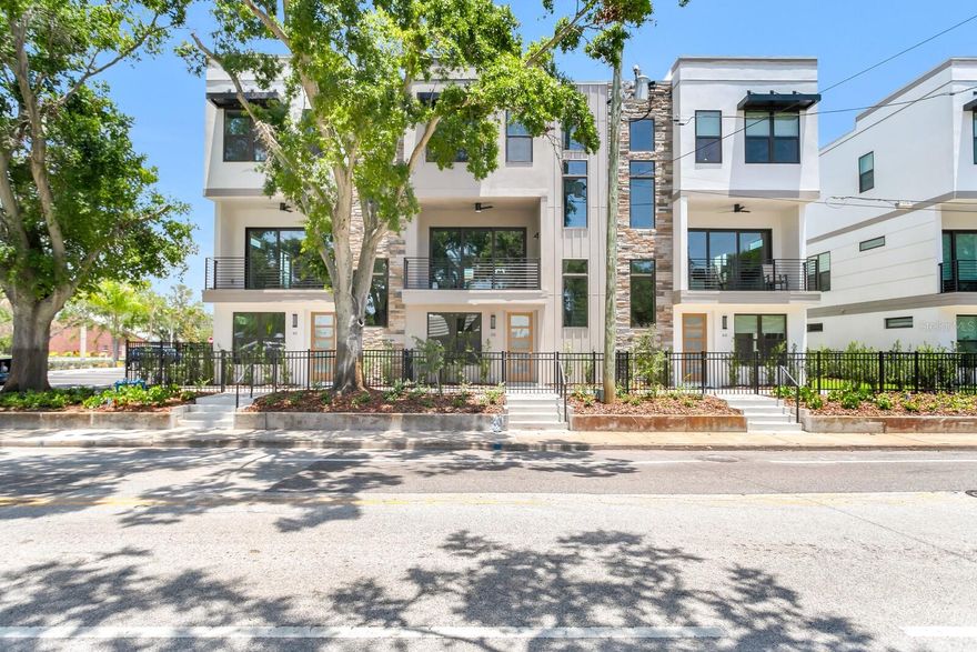 Now complete and move-in ready, this beautifully finished Strum Place residence offers modern living with timeless St. Petersburg charm in a secure, gated enclave of just nine luxury townhomes. This home features hardwood flooring throughout (no carpet), upper-stack cabinetry in the kitchen and wet bar, and an epoxied two-car garage floor. Spanning three levels, the flexible layout includes a ground-floor bedroom with ensuite bath and private entry, ideal for guests or a home office. The main level impresses with 10' ceilings, oversized windows, and an open kitchen, dining, and living space that flows to a private balcony, complemented by a large island, quartz countertops, walk-in pantry, ceramic tile backsplash, full KitchenAid appliance suite, and nearby half bath. Upstairs, two additional ensuite bedrooms include a spacious primary suite with walk-in closet, dual vanities, and frameless glass shower, along with a full laundry room with sink and extra storage. Every residence is elevator-ready with aligned closets on all levels, and one of the remaining homes includes a fully installed elevator. Situated on Central Avenue in a non-flood zone, Strum Place offers unbeatable access to the SunRunner, Pinellas Trail, shops, dining, downtown St. Pete, and the beaches—modern living, historic charm, and a rare opportunity.