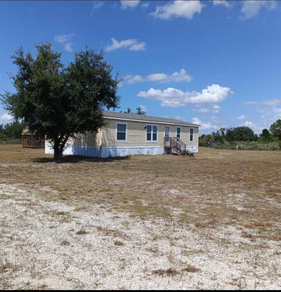 Who would like this home sitting on vast acreage in the midst of quiet and peace galore? Here's waiting your private sanctuary on 2.5 acres. New 2023 manufactured home- 3 bedrooms/2 baths. New appliances (washer/dryer/freezer do not convey). Owner added cabin/shed (12x24)--can be used for storage or bedroom (not currently connected to utilities). New spacious cabin. Owners added the following enhancements: septic tank, additional tank and well, a cute pond, 6' galvanized chain link fence, leveling of land ,woods clearing, road inside gate, bridge outside gate, cabin/shed and anchor for shed. Enjoy the owner planted fruit trees--mango, apple, avocado, oranges, grapefruit, fig, pomegranate, soursop and peaches. Here's serenity at your fingertips.