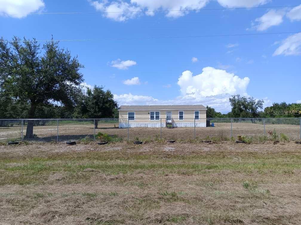 Who would like this home sitting on vast acreage in the midst of quiet and peace galore? Here's waiting your private sanctuary on 2.5 acres fully fenced in. New 2023 manufactured home- 3 bedrooms/2 baths. Newish roof 3 years old. New appliances (washer/dryer/freezer do not convey), new floors, new lighting fixtures, quartz countertops. Owner added cabin/shed (12x24)--can be used for storage or bedroom (not currently connected to utilities). New spacious cabin. Owners added the following enhancements: septic tank, additional tank and well/self cpntained water supply, a cute pond, 6' galvanized chain link fence, leveling of land ,woods clearing, road inside gate, bridge outside gate, cabin/shed and anchor for shed. Enjoy the young fruit trees--mango, apple, avocado, oranges, grapefruit, fig, pomegranate, soursop and peaches. Here's serenity at your fingertips.
