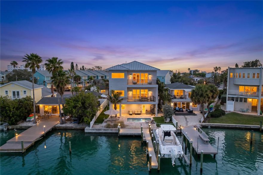 Tucked along a quiet waterfront street in the heart of Sunset Beach, this custom-built coastal residence offers a refined take on island living—where clean design, quality finishes, and a seamless connection to the water come together effortlessly. Completed in 2019, the home features 4 bedrooms, 4 bathrooms, and almost 3,500 square feet of thoughtfully designed living space .

Inside, shell stone flooring runs throughout the entire home, including the bathrooms, creating a cohesive and timeless look. The open living areas are filled with natural light and flow into a gourmet kitchen with quartz countertops, a large island, soft-close cabinetry, and premium Jenn-Air appliances with a gas range . An elevator services all levels, adding everyday convenience.

The outdoor space is designed for easy enjoyment, with intentionally low-maintenance landscaping framing a heated pool with color-changing LED lighting and a sun shelf, surrounded by paver decking. A mini bocce ball area along the side yard adds a relaxed, social element.

At the water’s edge, a composite dock with electric and water connections provides immediate access for boating or simply enjoying the view . Multiple balconies and a spiral staircase enhance the indoor-outdoor flow.

Built with elevated construction for peace of mind and supported by features such as a durable metal roof and generator-ready systems, the home combines comfort with quiet confidence.

All just moments from the beach and the laid-back charm that makes Sunset Beach one of Treasure Island’s most desirable coastal communities.