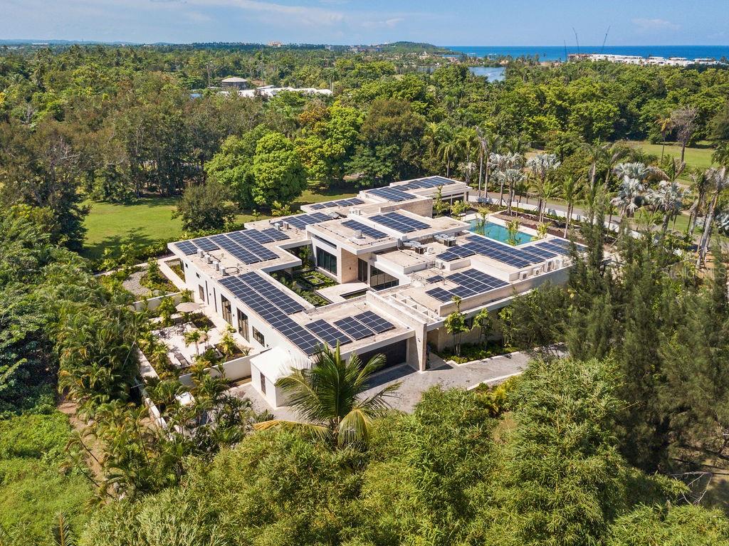 Dorado Beach Estates 17
This distinctive estate in Dorado Beach Estates is a true one-of-a-kind residence in a class of its own. Unparalleled luxury, modern elegance, and grand spaces perfectly describe Estates 17.
This newly constructed home with a total area of approximately 20,629 sq feet, is located in the exclusive gated community of Dorado Beach Estates, one of the most exclusive, private and desired neighbors within Dorado Beach a Ritz-Carlton Reserve.
From the moment you pass through the front entrance, you know that you have arrived someplace very special. A stunning 30,000 gallon Koi Pond welcomes you and brings the outdoors in, providing soul soothing views from almost every room in the home.
The main home offers 4 bedrooms with ensuite bathrooms, including an office/flex bedroom space. Additionally, it features an attached fully equipped Casita with separate entrance and a 6,511 sq foot basement with additional parking space and three multi-use air conditioned rooms.
All the interiors enjoy exceptional height and warmth thanks to the beautiful travertine floors and the floor to ceiling Coralina Wall throughout. Together with 10’ sliding doors they create a sense of space and make the most of the abundant light and the views. Textures and materials such as Taj Mahal granite, Exotic Sahara Noir and Velluto Onyx countertops show that no expense was spared.
The modern, fully fitted, open plan main kitchen with views of the pool features Sub Zero Refrigerator and Freezer, Wolf appliances (microwave, steam oven, 60’’ range with (2) ovens, a commanding 11’x6’ imported marble island and Poliform built-in cabinets throughout. For those who appreciate entertaining the home features an additional Prep Kitchen filled with (2) Refrigerators, (2) Freezers, (2) Wine/Champagne Refrigerators (all Sub Zero), electric cook top, a polished Taj Mahal granite counter top 11x 4.5 ft island and plenty of additional storage.
The elegant dining room is positioned overlooking the Koi Pond and features a reflective floor to ceiling mirror tile, which showcases the reflection of the Koi Pond and it’s fragrant flowering water lilies.
With views over the pool and golf course, a master retreat for relaxation and entertainment, an expansive bathroom area and featuring a commercial Gym. The master bath has a stunning 2 person infinity spa tub with Calacatta Gold marble and separate His and Hers commode closets, showers, and walk in closets, for those who appreciate their own spaces and privacy. The sale of the home includes all the Gym’s state of the art equipment.
Through the elegant sliding pocket doors, you’ll find a spacious outdoor terrace that features a 85’ x 30’ salt water swimming pool, with imported Indonesian Sukabumi cut stone tile.
Finally, eco-friendly and sustainable amenities include a (238) Hanwa solar panels, 9 Tesla batteries, commercial Volvo generator, commercial grade water filtration & reverse osmosis system and (2) 2,500 gallon water cisterns. Additionally, the villa incorporates all the state-of-the-art home automation features such as Insteon lighting, Bose multi-room audio and separately controlled HVAC systems in each room, security system with cameras and pool lighting controlled from smart home applications on the owner’s phone and tablet.