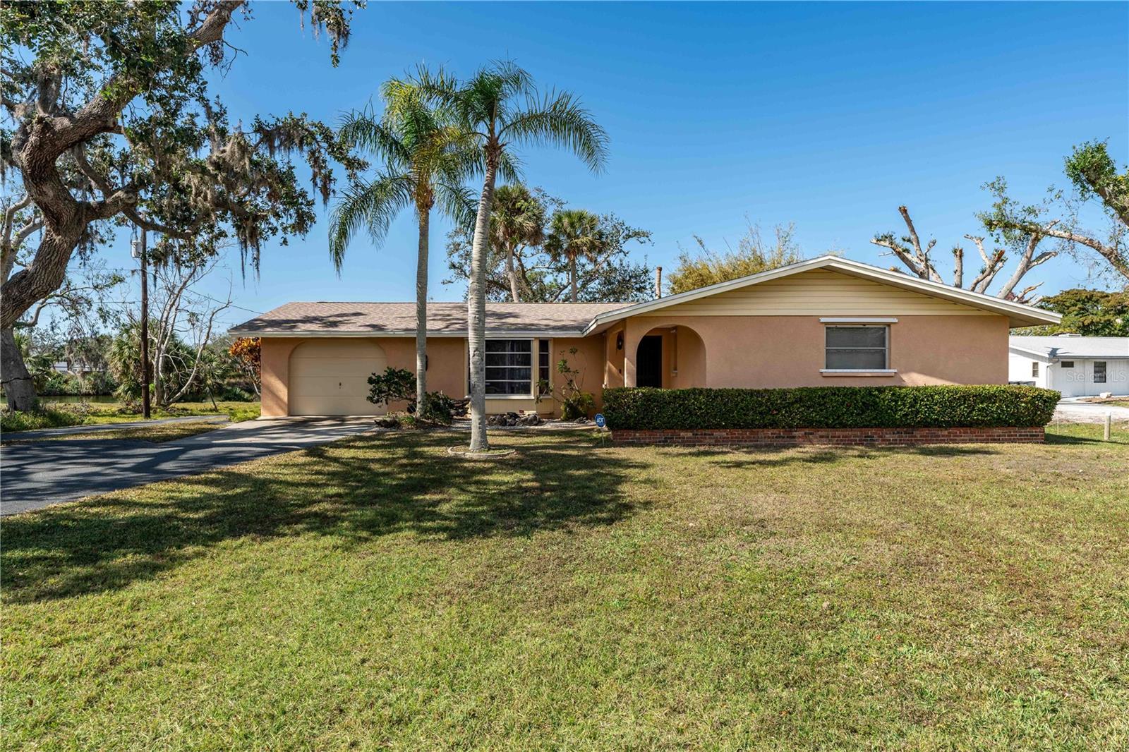 One or more photo(s) has been virtually staged. LOCATION ALERT!! This is a Unique Find in a Prime location. The Home is on 1.17 acres of Beautiful Lake Front Property in a Quiet Neighborhood with No Thru Traffic. Very Close to Shopping Centers, Restaurants and other Amenities such as Medical Offices, Gas Stations, and just about Anything You Might Need. Only 3 Miles to The World Famous Siesta Key! Less than 10 minutes Drive to I-75 and Only About 1 Mile to the Legacy Trail Bike Path! This Home has Always been Very Well Maintained and Cared For. The Extra Large Living Room Connects to the Florida Room Giving You Plenty of Space to Entertain Guests. The Primary Bedroom and one of the Guest Bedrooms have Large Walk-in Closets. This Home has Never Flooded. Latest Improvements include (NEW ROOF 2023), (NEW AC 2022), (NEW WATER HEATER 2023), New Garage Door Opener 2024. There are 2 Garages. One that is Attached to the House and a Detached Garage that would be perfect for a WORKSHOP!! There are Hurricane Shutters for All the Windows to give you Peace of Mind During Storm Season. The Property has been Zoned to be Split into Two Half Acre Properties to Build Another Home if so Desired. NO HOA and NO CDD! There are Fruit Trees and Shade Trees on the Property. Enjoy the Abundant Serenity and Privacy with a Beautiful Lake View. Make an Appointment to see it Today!!