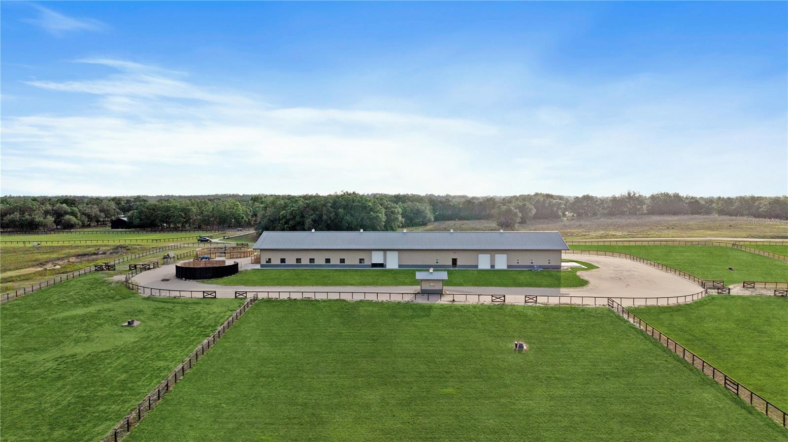 Three 10-Acre Parcels with Horse Barn, Office, and Endless Possibilities! Discover the perfect blend of cleared land, natural beauty, and equestrian amenities on these three contiguous 10-acre parcels—offering 30 acres of serene countryside in one of Florida’s most desirable rural areas. Each parcel features open, cleared land with large oaks lining the perimeter, providing natural privacy and shade, and the property is completely fenced and cross-fenced—ideal for livestock, horses, or recreation. A sprawling 9,240 sq ft barn includes a 5,400 sq ft horse barn with 20 stalls, a feed room, and ample tack storage, plus a 2,400 sq ft office area perfect for on-site management or potential conversion (buyer to verify with county/city). Additional equestrian amenities include a hot walker and round pen. While the barn and office were permitted at the time of construction for office space and barn use, a kitchenette was later added; buyer is advised to verify all permits, zoning, and intended use with the local building department. With easy access to main roads, no HOA, and endless possibilities for a private estate, horse facility, or weekend retreat, this property offers flexibility and natural beauty that are hard to find. Don’t miss this incredible opportunity to own 30 acres of prime Florida land with equestrian facilities already in place