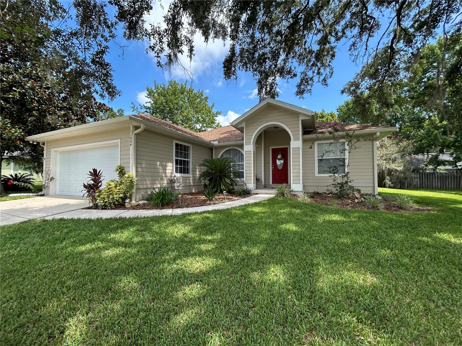 3/2 with Community Pool in Wellington Place
The home features a yard and neighborhood that offer a sanctuary of peace in NW Gainesville. Wellington Place has some of the friendliest neighbors and you are sure to get a polite wave or smile each time you visit. This very special three bedroom, two bathroom home has two separate living areas. The master and ensuite are secluded and complete with garden soaking tub, double standing shower, and oversized vanity with plenty of room in the large oversized walk-in closet. The two bedrooms offer full closets and bright airy windows. The bathroom has been updated with bright white tiles and soft hues that compliment all tastes.
Each view from your home is filled with lush trees with blossoms and every corner of your home has been lovingly tended and planted with a variety of plants and shrubs. Your new kitchen has a formal dining area and space for a breakfast nook. There's room for everyone in the living areas and the double doors the back patio have a privacy hedge for outdoor entertaining and play.
The home also includes pest control and lawn care to make it worry free living just for you to enjoy. Washer and Dryer included with rental. With a picturesque hilltop corner lot this home is joyful to come home to.
The location is absolutely perfect and within walking distance of Meadowbrook Elementary and also within biking distance to Fort Clarke Middle School. There are nearby restaurants and a fabulous Publix just a few miles away without the noise of traffic. 7.3 miles to UF and only 3 miles to Santa Fe College make this a dream commute with I-75 just a few minutes away from your front door.