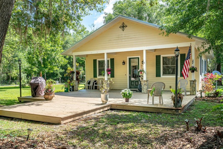 Custom 1 bedroom 1 bath home on 5 acres with detached 3 car garage and 1 bed 1 bath apartment/ in-law suite.  Additional 30x50 metal hobby barn with 12' tall roll up door, concrete floors and 100 amp power.  An additional pole barn and shed offer extra storage space.  The property is manicured like a park with beautiful trees, grass, pond, and outdoor stone fireplace for cooking or getting warm on cool nights.  The entire property is fenced, cross fenced and gated; driveways are complete with concrete and millings.  The main house is equipped with hardi board siding, metal roof, Anderson windows and doors, lovely hickory wood floors and kitchen cabinets, granite countertops, stainless gas range, stainless refrigerator, dishwasher, and built in microwave.  The cathedral ceilings, 8' tall entry and interior doors, and open floor plan make this great room feel very spacious.  The bedroom offers sliding glass doors out to the the covered back porch with a view of the back property.  Bathroom has travertine tile throughout, wood vanity with granite counters, and tub/shower.  A large wood deck and covered front porch create ample space for outdoor entertaining.  Don't miss out on this opportunity to own one of the few properties available in the country on a paved road and only moments to the New Smyrna Beach.