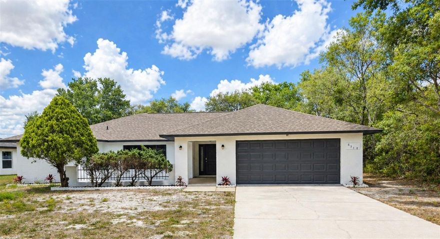 One or more photo(s) has been virtually staged. Spacious, beautifully renovated home with top-to-bottom updates inside and out. Major improvements include a new roof, new water heater, new appliances, new flooring, fresh interior and exterior paint, and all new light fixtures throughout. Step inside to an open, light-filled living space featuring vaulted ceilings and an inviting layout designed for both everyday living and entertaining. The fully updated kitchen showcases stunning countertops and modern finishes, creating a true focal point of the home. The primary suite offers a private retreat with an en suite bathroom featuring double sinks and a walk-in shower. A split floor plan provides added privacy, with three additional large bedrooms and a fully remodeled bathroom located on the opposite side of the home. Enjoy the outdoor living space with two large patios and a covered, screened lanai—perfect for relaxing or hosting gatherings year-round. The garage features an epoxy-coated floor for a clean, durable finish. Move-in ready with quality upgrades throughout—this home combines space, style, and functionality in one complete package.