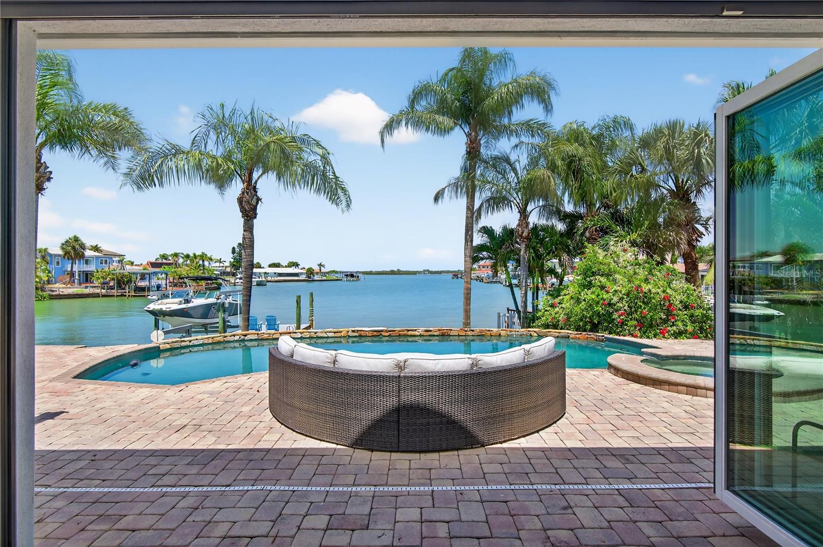 GORGEOUS OPEN WATER VIEW! ONE OF THE VERY BEST ON ISLAND ESTATES! ELEVATED 9.15 FEET BASE FLOOD- NEVER FLOODED! ASSUMABLE FLOOD INSURANCE AT ONLY $3750/year. TOTALLY UPDATED 4-BEDROOM 3 BATH OASIS! MOVE IN READY! VERY DEEP WATER CANAL SO BIG BOATS ARE WELCOME! INCREDIBLE OUTDOOR LIVING SPACE TO ENJOY THE ANNUAL BOAT PARADE RIGHT BEHIND YOUR HOUSE. READY FOR AN IDEAL 2ND STORY ADDITION. The interior is designed to embrace the view with expansive luxury bi-fold slider doors that fully open, seamlessly connecting the living space to the outdoors.The beautiful dark hardwood flooring could be easily lightend. Enjoy GORGOEUS morning SUNRISES PERFECTLY LOCATED IN THE CENTER OF YOUR VIEWS. Enjoy coffee or evening sunsets by your sparkling pool, all while overlooking a generous yard and wide waterway—ideal for entertaining or simply soaking in the coastal lifestyle. Additional upgrades include: TWO AC Units 2020/2021, Water Heater 2022 (gas), Garage Door 2022, Highend Appliances including GE oven /stove 2024, Samsung Dishwasher 2022. Washer and Dryer Convey. Patio Furniture and umbrellas convey. Built high and dry, this home has never taken on water, offering peace of mind and long-term value. All of this lifestyle and just minutes from Clearwater Beach, top restaurants, shopping, and the Clearwater Marine Aquarium, this home is your front-row seat to the very best of Florida’s Gulf Coast.