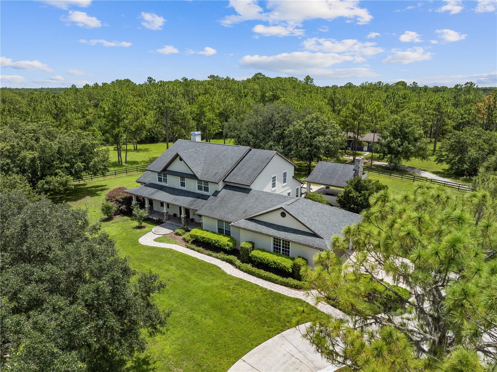 ***MOVE-IN READY | MOTIVATED SELLERS | NOT IN A FLOOD ZONE*** Ideally set on 7.25 cross-fenced acres within the highly-rated equestrian community of The Forest at Panther Ridge, this stunning Craftsman style home offers a unique multi-generational living experience. Featuring 4 bedrooms and 3.5 bathrooms in the main house, plus a 1 bedroom, 1 bath detached in-law suite, this property provides both luxury and flexibility for extended family living or guest accommodations. Surrounded by ancient forests, rolling green pastures, and over 17 miles of meandering private trails, experience unrivaled privacy while enjoying nature walks, horseback riding, elaborate gardens, and an abundance of undisturbed wildlife.
Completely remodeled in 2018 with a modern open concept floor plan, the main house boasts soaring cathedral ceilings and abundant natural light. Warm wood flooring flows through spacious dining and living areas. The chef's kitchen is generously appointed with gorgeous cabinets by Metro, Subzero 42” refrigerator and 24” wine storage, WOLF 48” 6-burner gas range with griddle, WOLF 24” microwave, and quartz countertops. The oversized great room sets the stage for entertaining with a floor-to-ceiling wood-burning fireplace, custom tiled mantle, and sliding doors leading to the outdoor oasis.
Enjoy the outdoors from the lanai boasting a heated saltwater pool and spa, with an enormous covered outdoor entertainment area featuring a 42” Alfresco grill, Subzero 24” outdoor refrigerator, wood-burning fireplace, and a huge TV area. At day’s end, retreat to the first-floor primary bedroom suite, boasting a sizable walk-in California closet, and an extensively remodeled spa-style bath with dual vanities, leathered granite countertops, and a glass tile shower. An ensuite guest bedroom, office, and powder room round out the downstairs space. Upstairs you’ll find a large bonus room, another fully renovated bathroom, and two large guest bedrooms with walk-in closets.
The detached in-law suite with a private entrance features a full bath with a glassed-in shower, living, dining, and kitchen areas, and a 1.5 car garage. All of this within close proximity to shopping, dining, entertainment, A-rated schools, healthcare, nature, and recreational options. Explore world-class beaches and nearby attractions such as Lakewood Ranch Main Street, Lakewood Ranch Waterside, and Sarasota’s vibrant cultural scene.
Schedule your private viewing today!