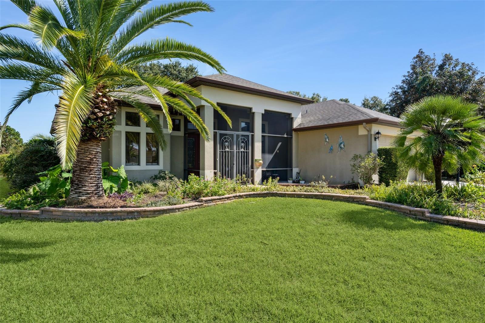 Welcome to the STERLING, the most desirable MODEL in LEGACY! This move in ready home in the Very Active 55+ gated community with FREE RV STORAGE. The home offers generous living space of close to 2600 square feet with 4 bedrooms! The 4th bedroom can be used as a versatile room, gym, media room or DEN. Spacious 3-CAR GARAGE includes workshop space that adds practical value and the garage refrigerator conveys with the home. The property is located on a premium LOT that has NO REAR neighbors, overlooking a retention area with lush landscaping with lots of privacy. This home features owner owned home security system. As you enter the home through a covered and screened in porch you approach a double door entry. Some of the key interior highlights include an open floor plan with 11’4” volume ceilings and 8-foot doorways. The Kitchen is open to the family room with a large breakfast bar, granite countertops, a gas stove, solar tube and a WINE Bar. All of this complemented by 42-inch wood cabinets with lots of storage space and a SOLAR TUBE to let in natural light. The home features a formal dining room area, a large family/living room with a combination of wood flooring, carpets in the bedrooms and tile. The family/living room has the 3-panel slider that leads to the lanai which is great for entertaining. The home has a split bedroom plan which is very popular and nice for company staying over. The primary bedroom is a luxurious retreat with double door entry and a sitting area, two walk-in closets—one of which is a FEMA-approved SAFE ROOM —and direct access to a covered lanai using sliders. The primary bathroom includes a garden tub, step-in shower, dual separate vanity sinks, linen closet and ample storage with separate toilet commode. You can open the windows on nice days and is great for entertaining that adds space to the living room/family room. The home is well-maintained, with a 2021 HVAC system and ROOF was replaced in 2020. The exterior includes a 536 square feet birdcage installed in 2018. Additional features include tiled areas like the back lanai with glass windows and fans, a retractable awning, and a gas portable fireplace. Fans throughout the home and in all bedrooms. Guest bathroom has a tub/shower and linen closet with corian counters. Lots of storage in the separate laundry room which also includes washer and electric dryer. Easy Water filtration system/deionizer was installed throughout the house to keep the pipes clean from calcium buildup. A 4-point inspection is available upon request. There are 4 rain barrels to retain fresh water for your landscaping. This 55+ gated community has lots of amenities which includes landscaping, cable, and WIFI with low monthly fees. This active residence club includes a beautiful resort style pool, hot tub, fitness center, Bocce ball, pickleball, billiards, card room, grand ballroom, tennis, baseball field, bike trails with mature trees and lots of areas for bird watching are just to name a few. Legacy is a mature stable community with its own conservation areas in Central Florida with lots of lakes and rivers nearby to enjoy. Legacy’s builders have won many awards. Lots of shopping and close to the turnpike. A short drive to the Disney attraction's, turnpike and airport. Outside neighborhood is Rodello’s Italian restaurant and dog park nearby.