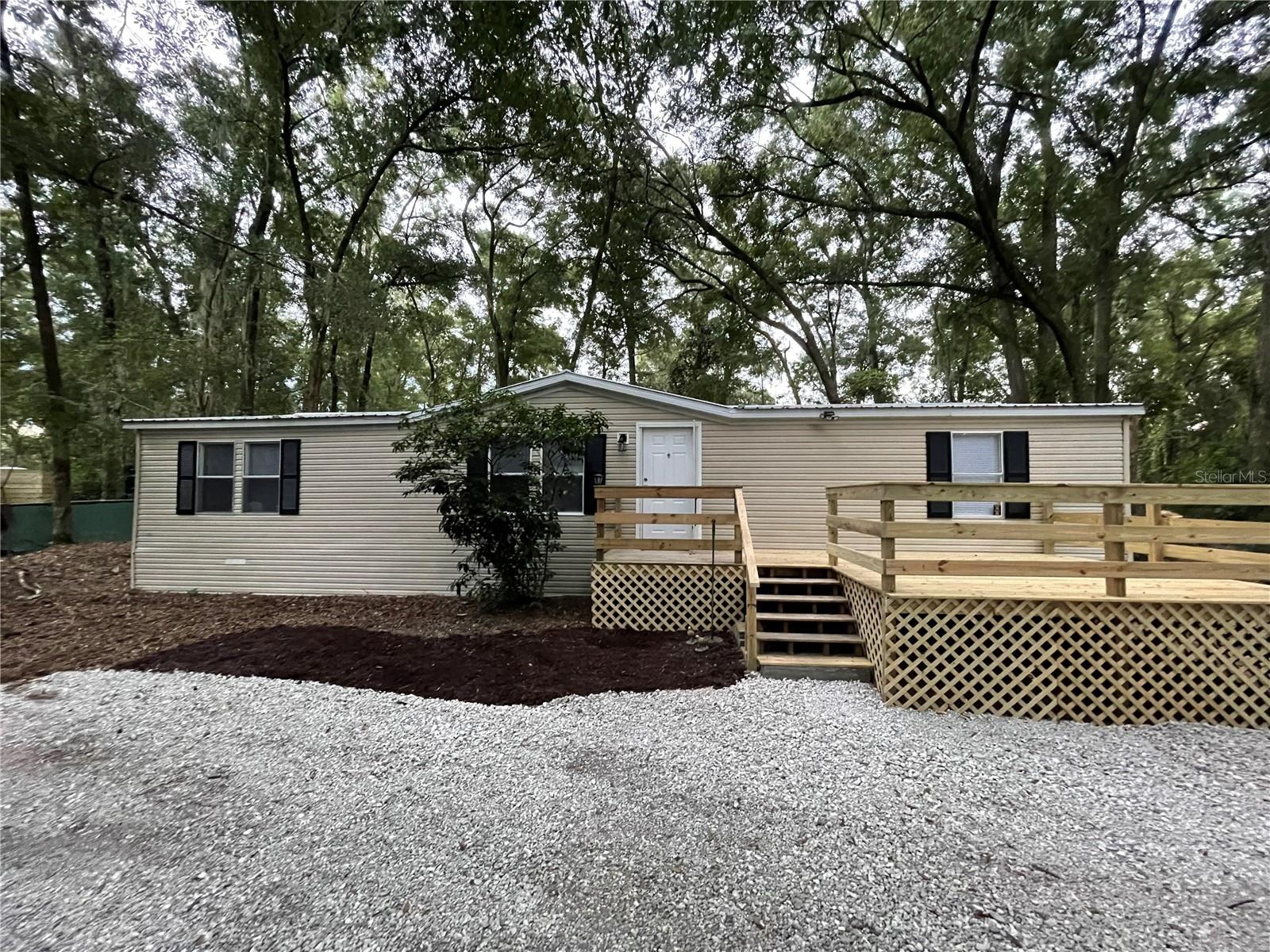 Updated bargain with a $5,000 BUYER INCENTIVE! Take a look at this renovated 4 bedroom, 2 bath 1512sf manufactured home in Alachua. Be the first to enjoy the brand new kitchen cabinets, island, brand new stainless steel refrigerator, range, microwave and dishwasher. Kitchen island with butcher block counter top and sitting space for some stools. Flowing throughout the home are new luxury vinyl plank flooring and tile flooring in the bathroom. Both bathrooms have new sinks, vanities and showers. Including a new soaking tub in the primary bath for some relaxation. Primary bedroom and two guest bedrooms have walk-in closets. Inside laundry room with barn door and walk-in pantry. New LED light fixtures and fans throughout. For added peace of mind there is a metal roof, recent HVAC and new water heater. $5,000 buyer closing cost incentive for an acceptable offer by 9/30/2025.