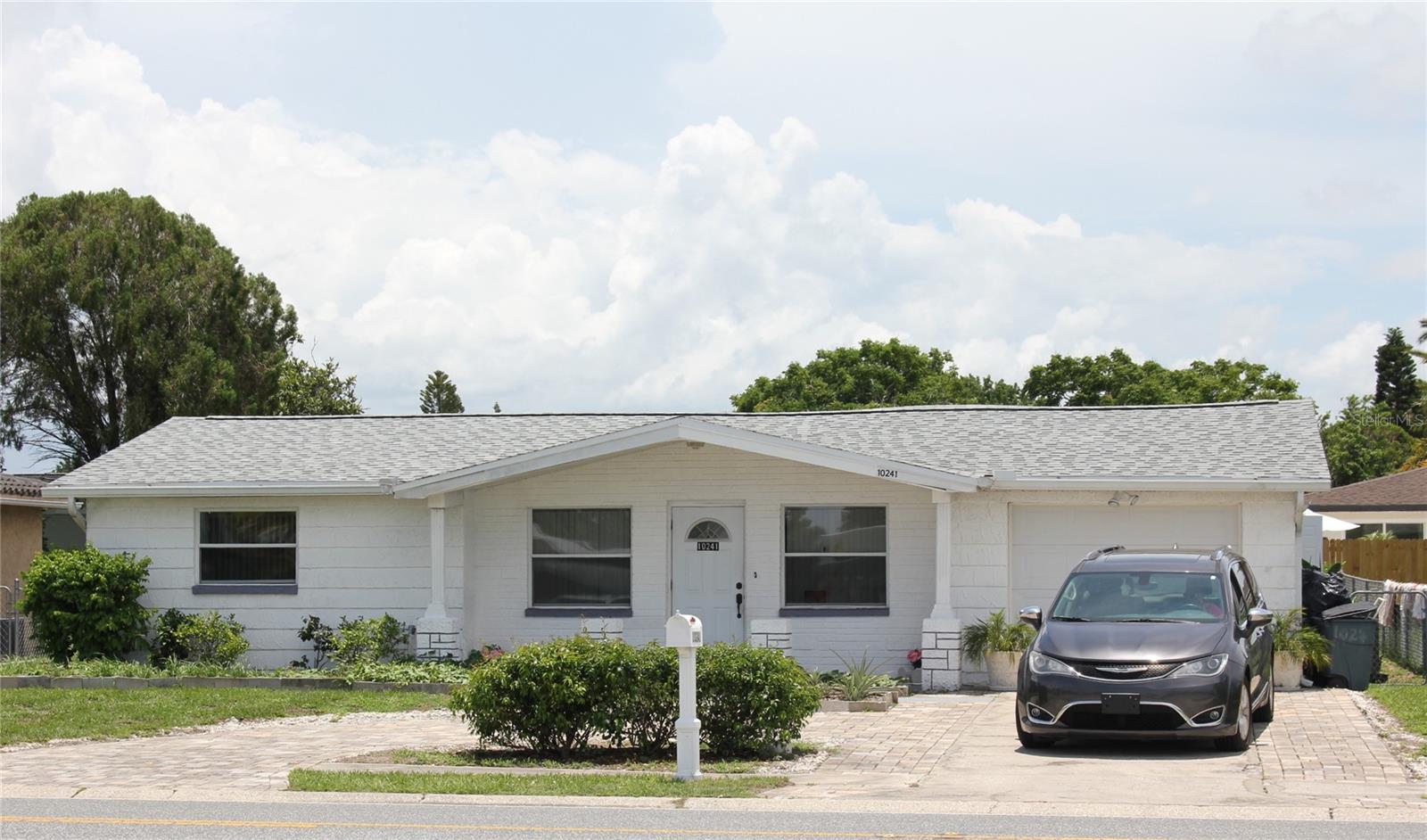 WOW! Move-in-ready 4-bedroom, 2.5 Bathroom home, with 1 car garage and circular driveway for 4 more parking spots. Located in Port Richey, this home offers all the major appliances, including a washer and dryer. The interior was just painted, a new roof was just installed, and a newer a/c system to keep you cool. The kitchen has terrific cabinet space and stainless appliances. It is adjoined to the dining room. The primary bedroom has a large walk-in closet and bathroom. Laminate flooring in the house makes it easy to keep clean. Nice fenced yard for your enjoyment. It is located close to shopping, schools, medical facilities, parks, restaurants, local beaches, public transportation, major roads, etc. Tenants must pass a background check, credit check, and have verified income. All room sizes are approximate, and the Tenant should do their own measurements. This property is professionally managed.