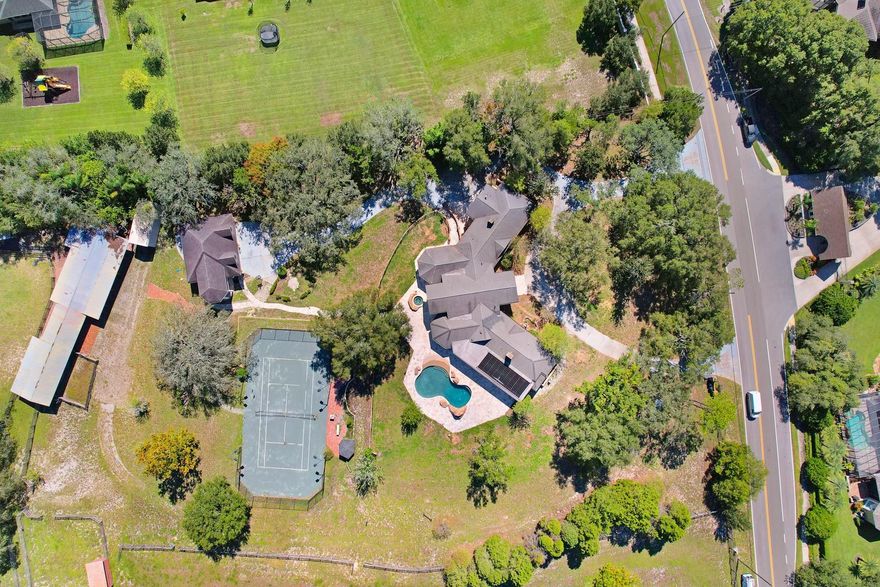 SPRAWLING, BREATHTAKING EQUESTRIAN ESTATE!! A north Pinellas gem! Beyond the private gate and circular driveway, a unique country retreat awaits. Functional and fabulous.... every inch of this custom property has a special attention to detail. This beautiful & whimsical 5 bedroom, 5 Bath home has a unique architecture, designed by Disney master artisans who successfully created the essence of old-world charm! The design is complimented by stone retention walls, rock accents, copper gutters, a custom pool and an enormous outdoor living space with a hot tub and fireplace. A rare find as a family home or compound & even more exclusive that it includes a functional equestrian estate! Savor the welcoming grand entrance to the wide-open great room with coffered, cathedral ceilings, custom moldings, views of the outdoor paradise & a dual sided gas fireplace. Every room is a conversation piece. Work from home? Enjoy the large executive style office & appreciate the artisan glass doors & elegant cabinetry. Need a break to unwind or enjoy some family time? The solarium off the executive office is the perfect room to relax & take in views of the grounds from the soaring floor to ceiling windows. There is also a downstairs gym/media/game room… endless possibilities! The kitchen is a masterpiece! Enormous chef inspired layout has custom wood cabinetry with decorative moldings, commercial grade Thermador appliances, a huge center island with a butcher block counter. The stunning views from the kitchen windows overlook the pool, tennis court (yes, it’s all yours!), rolling hills and the scenic, operational stables. The epitome of grand southern charm! The primary suite is a stroke of genius. The secondary bedrooms and baths are extravagant yet comfortable. The backyard leads to a LIGHTED Hydro-Grid Tru Court-Welch Clay Tennis Court! Perfect for the avid tennis player or the novice with big dreams! Luxurious reclaimed Georgia brick pathways line the property & offer another taste of southern charm. A driveway leads to a 6-car garage with an attached guest retreat. The possibilities are infinite… an in-law or nanny suite, man cave, private office, teen haven… so many options and it boasts a full bathroom & covered balcony with breathtaking views. Truly a special retreat. Bring your toys! There are opportunities for family fun & endless play on the sprawling grounds. And don’t forget the boat & RV! Plenty of storage in the RV shed with drive-through garage! The equestrian acreage has the same attention to detail & luxury as found throughout the home. It includes a total of 4 Paddocks/Pastures, 4 Stalls, wash station, birthing stall, training area, large tack room & a cedar storage area. The imaginative touch is extended to this area with fanciful hand painted murals to compliment the old country barn appeal. Comfort for the calvary is key… the area is complete with a sound system, fans & automatic water. This impressive manor is a must see. So many magnificent details! The property represents a perfect luxurious lifestyle or... perhaps a getaway refuge. Perhaps an equestrian boarding & training facility. Perhaps a family compound. Perhaps a dream come true! Prime location & ultimate privacy with over 7 acres, including an additional parcel of .78 acres, 45 ft. above sea level, yet only 5 miles to the Gulf Beaches. Come explore and delight in this rare opportunity! It must be seen to fully appreciate the splendor! Your country retreat awaits!