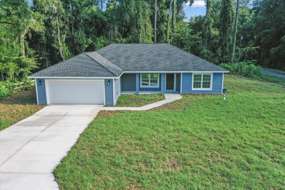 Introducing an exquisite newly constructed three-bedroom, two-bath home. This residence is designed to impress, featuring cathedral ceilings in the living room that enhance the sense of space and openness. The seamless open floor plan connects to a beautiful kitchen, complete with a large island, premium granite countertops, and stainless steel appliances. The home has LVP flooring throughout, ensuring both elegance and durability. Additional conveniences include an indoor laundry room and an 8x16 covered lanai, great for hosting gatherings or enjoying peaceful moments outdoors. The master suite is a sanctuary of luxury, offering a tray ceiling, a generously sized walk-in closet, and a master bath equipped with double sinks and a walk-in shower. Every element of this home has been meticulously crafted to provide unparalleled comfort, style, and functionality. Seize the opportunity to own this exceptional property. Located in Citrus Springs on a corner lot. Short drive to many local waterways and Crystal River. Your dream home awaits.