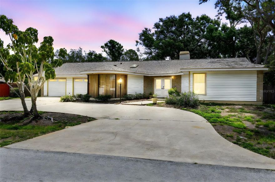 Spacious Pool Home with Endless Potential in a Prime Location Near Walsingham Park Discover a rare opportunity to own a generously sized pool home in a highly desirable area—just steps from the scenic 354-acre Walsingham Park. Located on a quiet, well-kept street where neighbors take pride in their homes, this property offers incredible space, a flexible layout, and solid construction—ready for your updates and personal touch. Set on a large homesite with a beautiful front yard, circular driveway, and a 2-car garage with separate doors, this home offers great curb appeal. Step through double half-glass front doors into a wide, welcoming foyer with ceramic tile floors and plenty of natural light. To the right of the foyer, a private guest wing features two oversized bedrooms with new luxury vinyl plank flooring and full-wall closets. A spacious vestibule offers additional privacy and includes a massive linen closet, while the large guest bathroom features ceramic tile flooring, generous counter space, and a dedicated storage cabinet. To the left of the foyer sits a sprawling kitchen that holds vintage charm and serious potential. Highlights include solid wood cabinetry, ceramic tile countertops, a vaulted ceiling with skylight, ceramic tile flooring, a large pantry, laundry closet, and a bright breakfast nook with sliding glass doors that lead to the screened lanai. Adjacent to the kitchen is a formal dining room with laminate vinyl plank flooring and mitered glass windows overlooking the front yard—ideal for future entertaining or renovation. The living space continues with an oversized, sunken family room featuring a vaulted ceiling, ceramic tile floors, plenty of recessed lighting, and a cozy gas brick fireplace with a full hearth and mantle. Beyond the family room, a bonus room with wet bar and luxury vinyl plank flooring offers endless flexibility—use it for games, hobbies, a home gym, or a future media room. The expansive primary suite is tucked away at the back of the home for added privacy. This room features vaulted ceilings, a skylight, carpeted flooring, and large windows that overlook the pool area. A bonus alcove within the room is perfe