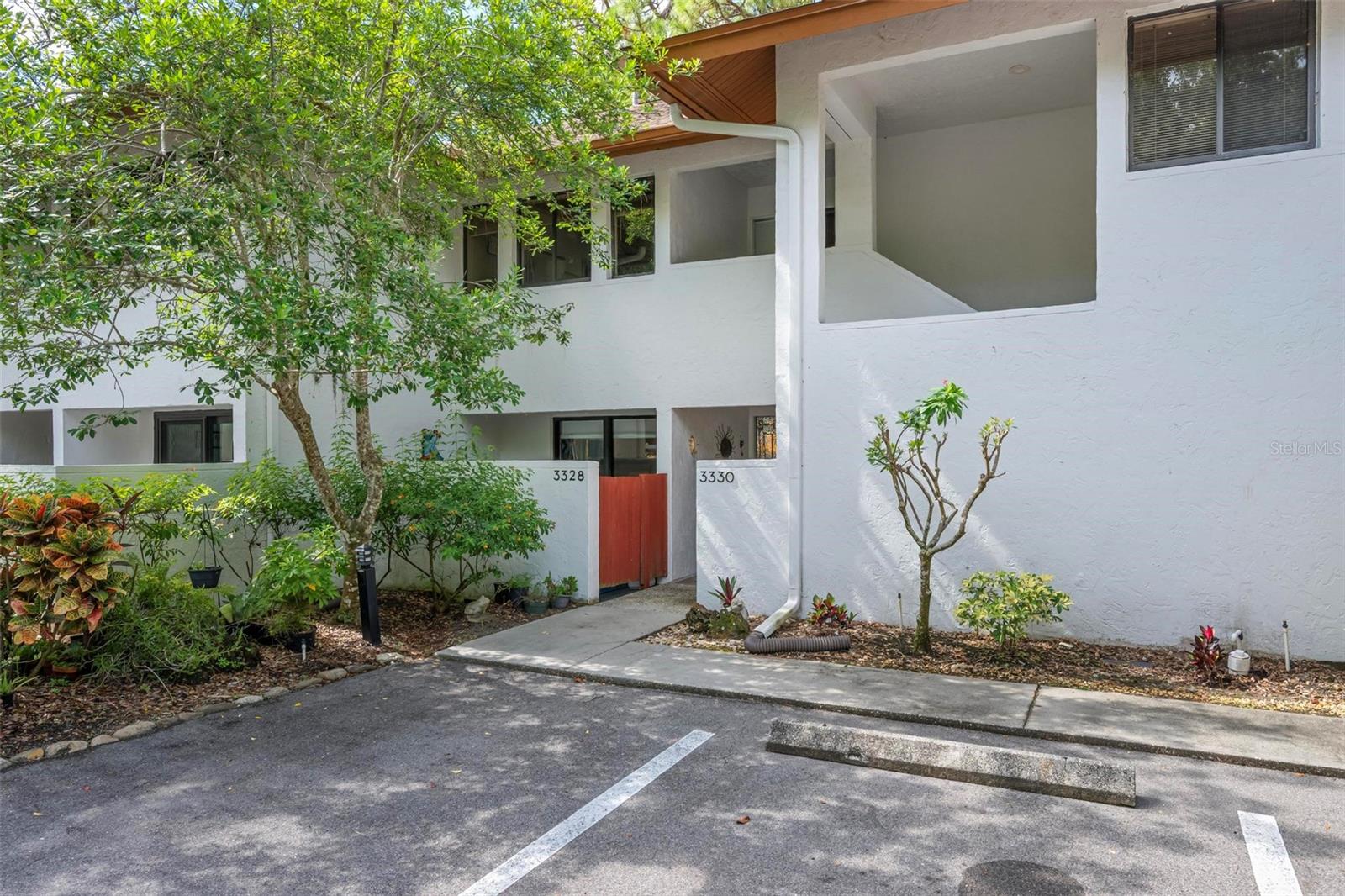 You’ll fall in love with this stunning modern condominium designed by the renowned Seibert Architects, a name synonymous with exceptional design in Sarasota. Perfectly nestled within the 72-acre nature preserve of Red Bug Slough, this hidden gem combines clean architectural lines, solid construction, and serene views of lush tropical grounds — all in the heart of Sarasota, Florida.
This 2-bedroom, 2-bath, second-floor residence offers oversized rooms ideal for entertaining, with an expansive living and dining area that flows seamlessly to a 26' x 10' air-conditioned balcony/bonus room complete with shelving. This versatile space is perfect as an artist’s studio, music room, or a peaceful retreat for relaxing and entertaining while surrounded by nature. French doors connect the balcony to both the studio and the primary bedroom, enhancing the open, airy feel. The home features luxury vinyl plank flooring in the bedrooms, living room, hallways and studio, complemented by decorative ceramic tile in the bathrooms and 7-inch baseboards throughout. The large eat-in kitchen offers a built-in desk, pantry, and convenient pass-through for gatherings. Contemporary touches include dramatic LED ceiling lights in the living room, built-in shelving, an updated walk-in closet, and other stylish upgrades that add to its warm and modern character.
Tree-lined pathways wind through the park-like community, leading to a sparkling pool and tennis court. A private covered front porch invites you to relax among lush foliage, while the designated carport and guest parking add convenience. Cose to all amenities: shopping dining, medical facilities,walking trails, schools and nearby marinas Additional features include a new roof in 2019, HVAC system new 2024
Refrigerator new 2023 & Microwave new 2018, and an in-unit washer and dryer located in the hallway laundry closet. Free grand piano is included! This tucked away, private community is a nature lover's dream!