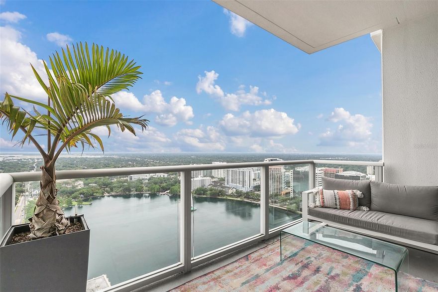 This beautifully renovated LARGER, HIGH FLOOR, LAKESIDE 2 BEDROOM HAS IT ALL!  It towers high in the building on the 31st floor with the most amazing views of iconic Lake Eola. In addition, it COMES WITH 2 LOWER PREMIUM PARKING SPACES, AUTOMATED BLACKOUT ELECTRIC BLINDS THROUGHOUT, AND CALIFORNIA CLOSETS in both master suite closets.  This is one of the larger interior 2 bedroom layouts in the building.  Features hardwood throughout, great lighting, stainless steel appliances, backsplash in kitchen, GAS stove, and very tasteful decor. The master bedroom includes 2 walk in closets with floor to ceiling
organization by Closets by Design giving tons of storage space, a large soaking tub, dual sinks, and a shower. The floor to ceiling windows have motorized automatic remote black out shades in both the living room and bedroom, so enjoy the sunrise each morning or enjoy sleeping in with the black out blinds. As soon as you step out on the balcony, you quickly understand why the lakeside units are always in such high demand. Washer and dryer are in the unit. The Vue is still the latest condo high rise building built in downtown Orlando. It offers 24/7 concierge and security, valet parking, and biometric fingerprinting. The building’s state-of-the-art amenities include an impressive fully- equipped fitness center, a yoga studio, a spacious lounge, theater room, business boardrooms for residents, grills, cabanas, a rooftop heated pool, basketball and tennis courts, and a dog run. This is urban luxury high-rise living at its finest!