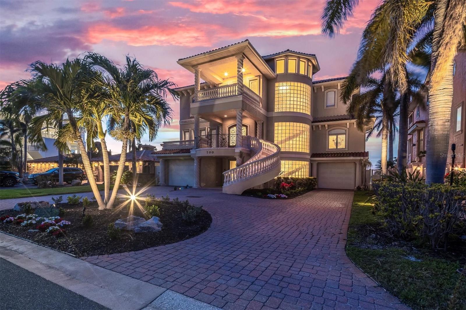 ~LOCATION, LOCATION, ELEVATION ~Welcome to your dream waterfront retreat, where breathtaking panoramic views of Boca Ciega Bay meet luxury living. Ideally positioned facing north near John’s Pass, this elevated 2007- Pici & Sons built home offers exceptional resilience, having withstood recent storms with minimal impact. View open water and balconies from every room in the home. Step inside to a grand foyer featuring a dramatic three-level curved staircase with custom ironwork beneath an impressive rotunda. Expansive living spaces showcase travertine floors with custom inlays, a gas fireplace, crown molding, and recessed lighting on dimmers. The gourmet kitchen boasts a Wolf gas range, Sub-Zero refrigerator, Bosch dishwasher, hidden walk-in butler’s pantry, and built-in appliance cabinet—a chef’s dream. The primary suite is a private sanctuary with Brazilian hardwood floors, a morning kitchen, an oversized custom walk-in closet with skylights, and a spa-like bath with a walk-in shower overlooking the water. Each of the four bedrooms has balcony access, and all three full baths are ensuite. Outdoor living is just as impressive, with huge front and rear terraces on two levels perfect for soaking in the wide-open water views. The 2019-installed dock with 13,000-lb lift accommodate your boating lifestyle across 70 feet of 2013 updated seawall, with easy access to the Gulf. The four-plus car garage offers ample storage, and there’s plenty of room for a pool. Additional features include an elevator to all three levels, Pella windows, ADT security system, Hunter Douglas custom blinds, a 2019 Culligan whole-house water filtration and softener system, two Rinnai tankless water heaters, and a reclaimed water irrigation system. All of this is just minutes from John’s Pass Village on wide open deep water, with top-rated dining, shopping, and entertainment. A rare opportunity to own a true waterfront gem—schedule your private showing today
