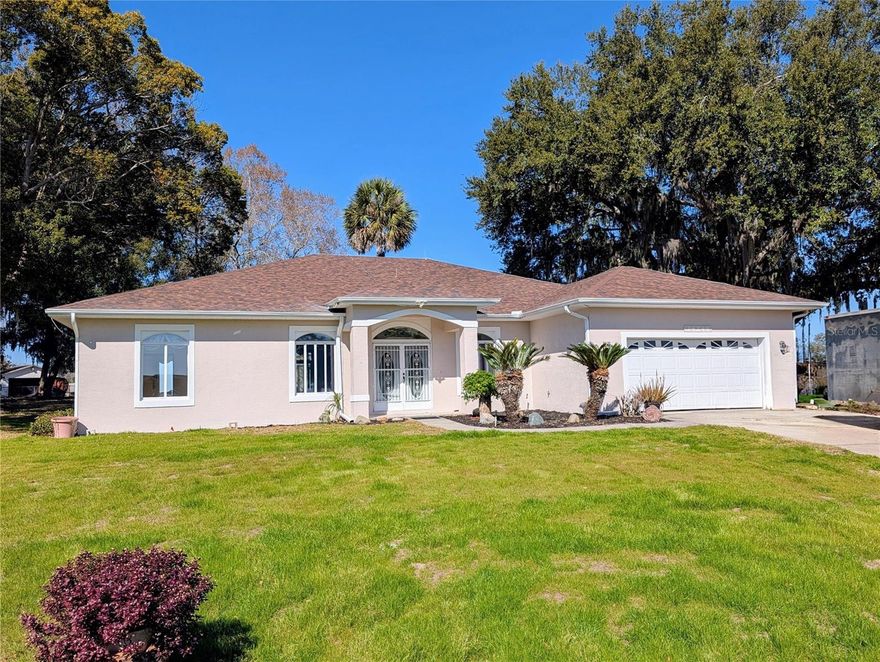 Discover this 3/2 concrete block home nestled at the end of a quiet cul-de-sac. Situated on a sprawling 0.67-acre lot with beautiful Lake Griffin views from your front porch. The generous 2,371 sq ft floor plan features an inviting open concept design, with the living room flowing seamlessly into the updated kitchen. Recent improvements include new windows and sliding glass door glass, septic drain field, exterior paint, 2026 AC, and a 2022 roof. Kitchen comes equipped with built-in oven and range, plus washer and dryer included.

The attached 2-car garage provides ample storage, while the large lot features a storage shed for additional space. Enjoy the best of both worlds with city water for household use and well irrigation for landscaping. Conveniently located near The Villages for endless shopping, dining, and entertainment options. NO HOA/CDD fees. Furnishings are optional.