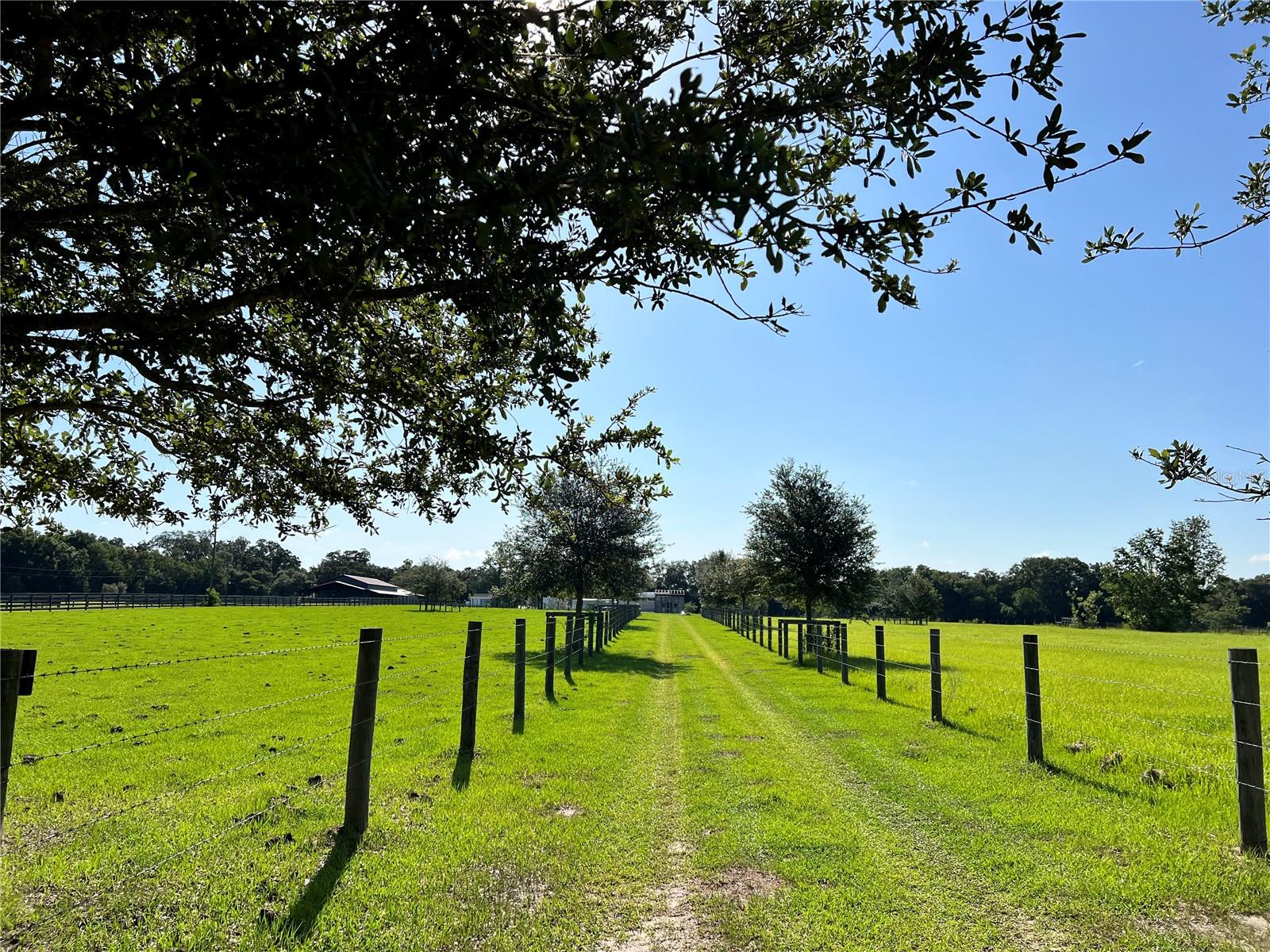 This breathtaking 10 acres is cleared, fenced and cross-fenced. Currently has seller's cattle. Building already started (with permits) with concrete walls (20 x 40 safe house and barn 46 x 70), both with a large patio slab in front. Most building materials will go with sale. Well and septic in place, 2 sheds buildings and trailer go with sale. This property is flood zone X and is high and dry. There is a retention area in the rear of the property, along with some hundred year + oak trees! 4 miles from the Villages and about 10 miles from Hospitals.