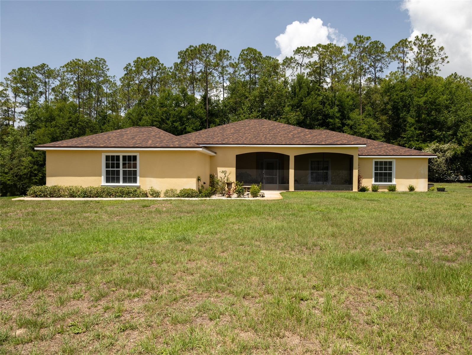 This spacious home sits on a 1.07-acre lot and features a 3-bedroom, 3-bath split floor plan offering privacy. Ceramic tile flooring throughout enhances durability and style. The formal dining and expansive living rooms contribute to an open, airy feel. The kitchen includes wood cabinets, granite countertops, and a breakfast bar, ideal for casual dining and entertaining. The large primary suite has dual walk-in closets and an en suite bathroom with a dual sink vanity, soaking tub, and separate toilet room. Each bedroom has a private bathroom, ideal for family and guests. Enjoy the oversized lanai (55x16) – an enclosed outdoor living area that provides additional space for relaxing and entertaining year-round. Recent updates include a new roof installed in 2024 and an HVAC unit just 5 years old. Appliances such as the washer/dryer, range, microwave, dishwasher, and garbage disposal are all included for your convenience. Located in The Woodlands of Rainbow Springs, this 1+ acre property offers easy access to local shopping, churches, schools, medical offices, the Rainbow and Withlacoochee Rivers, as well as Rainbow Springs State Park. Don’t miss out—call today to schedule your tour!