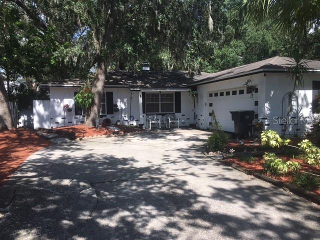 NO HOA! Must see this 3 BR 2 BA single family residence in Brandon, FL with attached 2-car garage! This solid concrete block construction home features a split bedroom plan, laminate floors in bedrooms and tile floors throughout the main areas. The spacious open-concept kitchen, living, and dining room arrangement creates a welcoming flow, highlighted by a beautiful wood-burning fireplace and a large window that fills the space with natural light. The west-facing property provides warm, golden light and beautiful sunset views, while its location on a quiet street offers safety and peace of mind. A small garden in the front yard adds charming curb appeal, complemented by a stunning mature palm tree that enhances the property’s character. Step outside to enjoy the beautiful outdoor lounge area on the open patio, complete with chain link fencing and rolled bamboo privacy panels, all overlooking a lush backyard filled with palm trees, vibrant plants, and greenery. A screened patio adds even more space for relaxing or entertaining. All appliances, including washer and dryer, are included, making this home truly move-in ready. With short-term leases allowed, it’s a fantastic investment opportunity as well as a personal residence. Seller financing available. Do not wait, it will not last long!